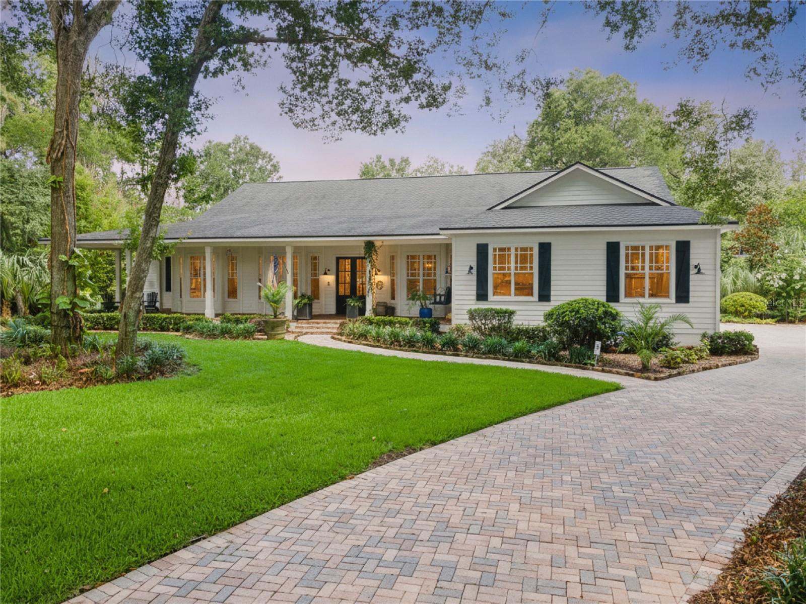 Perfectly positioned on nearly one acre within the exclusive Reserve section of Fish Hawk Trails, this custom Southern-inspired estate combines timeless architecture, exceptional craftsmanship, and refined luxury behind the security of a 24-hour gated entrance. With just under 4,700 square feet of thoughtfully designed living space, soaring 10-foot ceilings throughout, elegant cove lighting in every room accented by crown molding, and impeccable attention to detail create an atmosphere of timeless sophistication.

A wide pavered wraparound porch welcomes you home, while rich hardwood floors, extensive architectural millwork, bay windows, and custom details create warmth and character throughout. The spacious family room features a floor-to-ceiling stone wood-burning fireplace and opens seamlessly to the screened lanai and resort-style outdoor living areas. The gourmet kitchen is the centerpiece of the home, appointed with quartz countertops, a 48-inch gas range, a custom-crafted range hood, farmhouse sink, drawer microwave, walk-in pantry, beautifully crafted built-in wine closet, and abundant custom cabinetry.

The primary bedroom is a luxurious sanctuary with French doors leading to the lanai, dual walk-in closets, and a spa-inspired bath highlighted by a wood-inlaid barrel ceiling, marble vanity, oversized glass-enclosed shower, separate soaking tub, and shiplap accent wall. Every secondary bedroom features its own walk-in closet, while Bedrooms 2 and 3 offer beautifully remodeled en-suite bathrooms with high-end finishes.

Designed for entertaining, the home includes an expansive game room with an oversized closet that is currently utilized as a fitness room. The dedicated theater room is complete with its own mini kitchen and adjacent half bath, making it ideal for movie nights, sporting events, or hosting guests. A spacious laundry room with a utility sink and built-in drop zone adds everyday functionality, along with a dedicated 14-by-18-foot interior storage room offering exceptional space for seasonal décor, organized storage solutions, hobbies, or future customization.

Step outside to a private backyard oasis where mature landscaping creates a peaceful backdrop for outdoor living. The screened lanai overlooks a sparkling saltwater pool, heated spa, and oversized paver deck with generous gathering areas. An outdoor bar and built-in grilling station make entertaining effortless, while the detached clubhouse offers endless possibilities as a workshop, studio, or hobby space.

Additional highlights include a central vacuum system, a brand-new water heater, and a private irrigation well that helps maintain the lush landscape while significantly reducing water costs. The oversized side-entry four-car garage features impressive 12-foot ceilings, providing exceptional overhead storage and ample space for vehicles, recreational equipment, and workshop needs.

Fish Hawk Trails is one of Lithia's premier luxury communities, offering 24-hour gated security, scenic walking trails, tennis courts, playgrounds, and a peaceful natural setting. Residents also enjoy access to top-rated schools, nearby shopping and dining, parks, golf, and convenient access to Tampa, MacDill Air Force Base, and Gulf Coast beaches. Luxury, privacy, and exceptional craftsmanship come together in one of Fish Hawk Trails' most distinguished homes. Shown by appointment only.