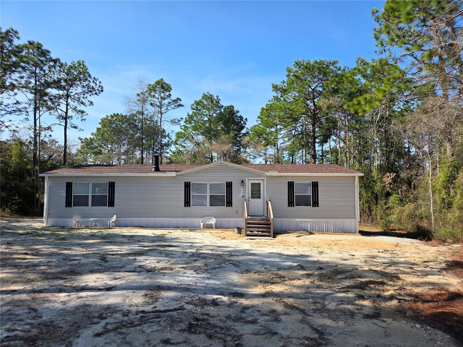 PRICE JUST REDUCED!!  168,000!!  BEAUTIFUL COUNTRY RETREAT! CASH, VA OR TRIAD FINANCIAL SERVICES. Spacious open concept with living room, dining room and new kitchen. Barn door to the laundry room with washer and dryer and cabinet for storage. This is a 3 bedroom 2 full bath home with a brand new master bathroom, oval tub with walk-in tile shower, beautifully done. Large master bedroom and walk-in closet. The 2 guest rooms are a good size too, with walk-in closets. All freshly painted. The kitchen has new cabinets, center island, Refrigerator, Range, Microwave, new dish washer and garbage disposal. Formica counter tops. County sliding door to the laundry room!  New laminate flooring through out and new plumbing. The A/C works well and has been serviced and inspected. Outside is a new meter with electric underground, new shingled roof with new gutters, new well, septic recently pumped out and inspected. Topped of with new skirting makes this home practically all new!! Home is a second set and may not qualify for FHA financing. Great place to entertain and raise your family. Just one lot off the paved road. Just 35 minutes to all the horse events, WEC, HITS and BLK PRONG. If you like fishing its about 35 minutes to Cedar Key.  Easy to find.