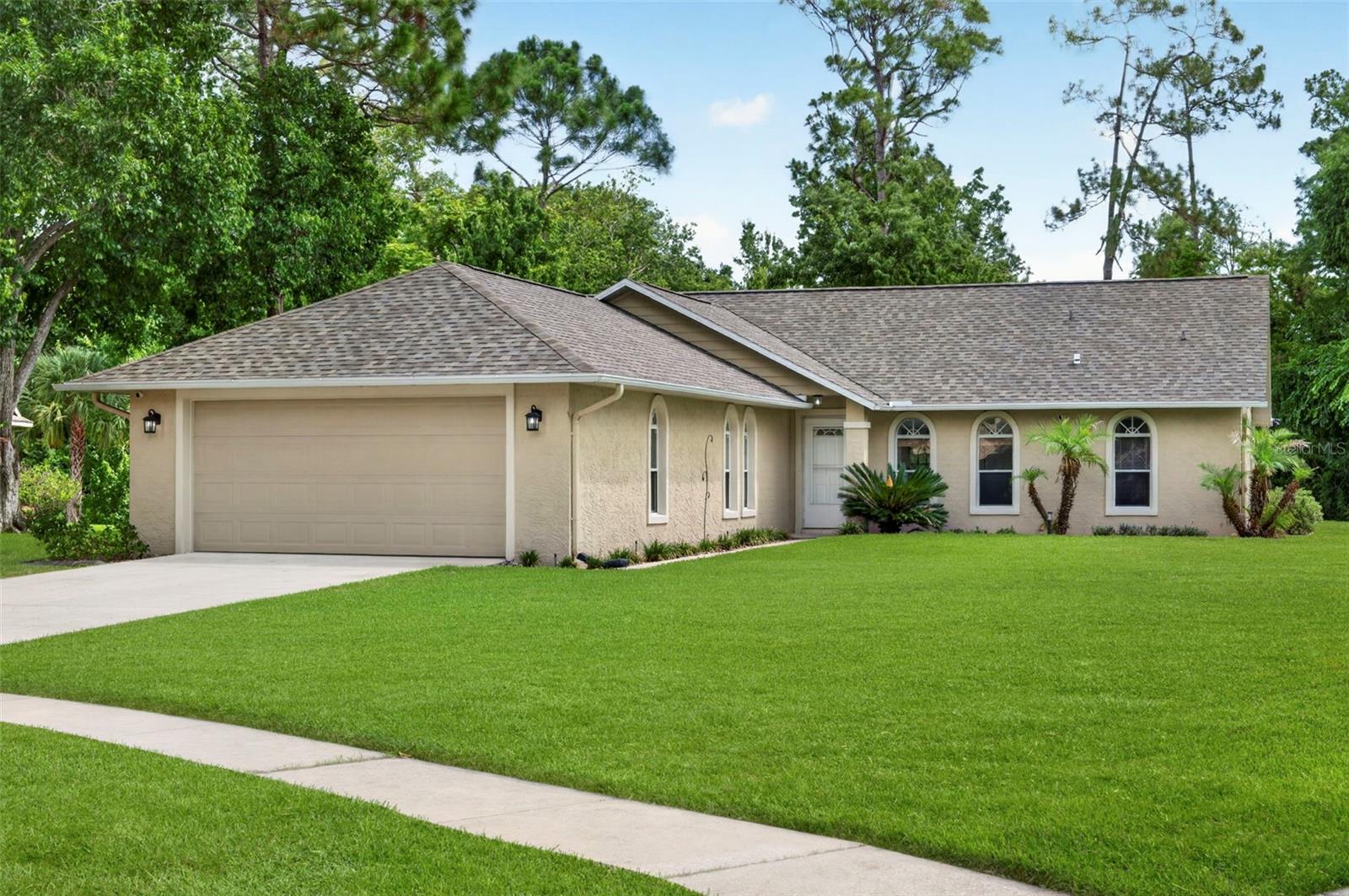 Welcome home to this beautifully maintained 3-bedroom, 2-bathroom residence situated on an oversized .34-acre lot backing to a peaceful creek, offering the perfect setting for relaxing evenings and enjoying nature right from your backyard. Recent updates include a brand-new roof and brand-new flooring, giving buyers peace of mind and a fresh, modern feel. Inside, soaring vaulted ceilings and a split-bedroom floor plan create an open and functional layout. The spacious primary suite features two closets, double vanities, and a beautifully renovated bathroom with a custom-designed shower. The eat-in kitchen offers an abundance of cabinetry, ample counter space, and a convenient built-in desk, making it ideal for both everyday living and entertaining. The secondary bedrooms are generously sized with deep closets, while the guest bathroom includes a tub/shower combination. An enclosed Florida room provides flexible space perfect for a home office, hobby room, playroom, or additional living area. Step outside to the paver patio and enjoy the privacy and tranquility of the expansive backyard overlooking the creek. Conveniently located near shopping, dining, medical facilities, major roadways, and just a short drive to the beach, this home is also zoned for highly sought-after Port Orange schools. With a 2-car garage, thoughtful updates, and an exceptional oversized homesite, this property offers the perfect blend of comfort, space, and location. Schedule your private tour today and discover why this could be the perfect place to call home.