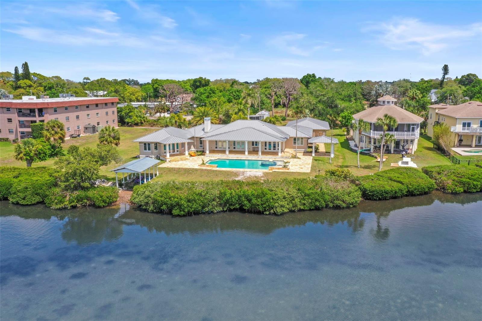 One or more photo(s) has been virtually staged. Tarpon Springs Coastal Estate 

Tucked away on nearly 2.5 private acres near Sunset Beach, this rare waterfront estate captures the essence of  Florida living — private, expansive, and built for a true coastal lifestyle. With approximately 150 feet of  Gulf waterfront, this is the kind of property that’s becoming increasingly hard to find in Pinellas County.

Launch kayaks right from your backyard from your covered boathouse, explore winding coastal waterways, or bring in a flats boat on high tide. Just minutes away, the Sunset Beach boat ramp offers effortless access to the Gulf, creating the perfect setting for boating, fishing, and everyday waterfront living.

Inside, the home spans a spacious layout with soaring vaulted ceilings and natural light pouring in through skylights, creating an open, airy feel throughout. The main living areas are designed for both comfort and entertaining, anchored by a large family room that flows seamlessly to a covered back porch overlooking the pool and stretching out toward Gulf-facing views — where evenings are best spent entertaining as the sun sets and dolphins play just beyond your backyard.

The residence features 5 bedrooms and 4 bathrooms, including two primary suites, each complete with walk-in closets and private en-suite bathrooms — ideal for multi-generational living, hosting guests, or creating a true owner’s retreat. Additional bedrooms are generously sized, offering comfort and flexibility for family and visitors alike.

A dedicated office/flex space provides the perfect setup for working from home, a gym, or creative studio, while a large laundry room adds everyday convenience.

The kitchen is ready to be transformed into a true showpiece — envision a beautifully designed chef’s space overlooking tranquil water views, complete with a dedicated gas range, double ovens, and an expansive layout built for gathering and entertaining.

Major improvements have already been completed, including all new HVAC systems in 2025, updated LED lighting throughout, new drywall, and fresh interior and exterior paint — offering a clean, solid, and well-maintained canvas ready for your vision and personal touch. A metal roof, resort-style pool, and detached 3-car garage add both durability and versatility to the property.

Designed by locally recognized Hoffman Architects in 2007, the home carries strong architectural bones and character, making it an ideal foundation for a custom luxury transformation.

Located in a golf cart–friendly community, you’re just a short ride to downtown Tarpon Springs, where local shops, restaurants, bars, and the world-famous Tarpon Springs Sponge Docks create a vibrant coastal lifestyle unlike anywhere else.

Properties like this don’t come around often — private acreage, waterfront access, and unlimited potential all in one of the Gulf Coast’s most unique coastal settings.

***Zoned RM – Residential Multi-Family District. RM zoning in Tarpon Springs, FL, stands for Residential Multifamily District, designed to provide for multi-family dwellings at varying densities..To BE VERIFIED BY Buyer & Buyers AGENT.***
