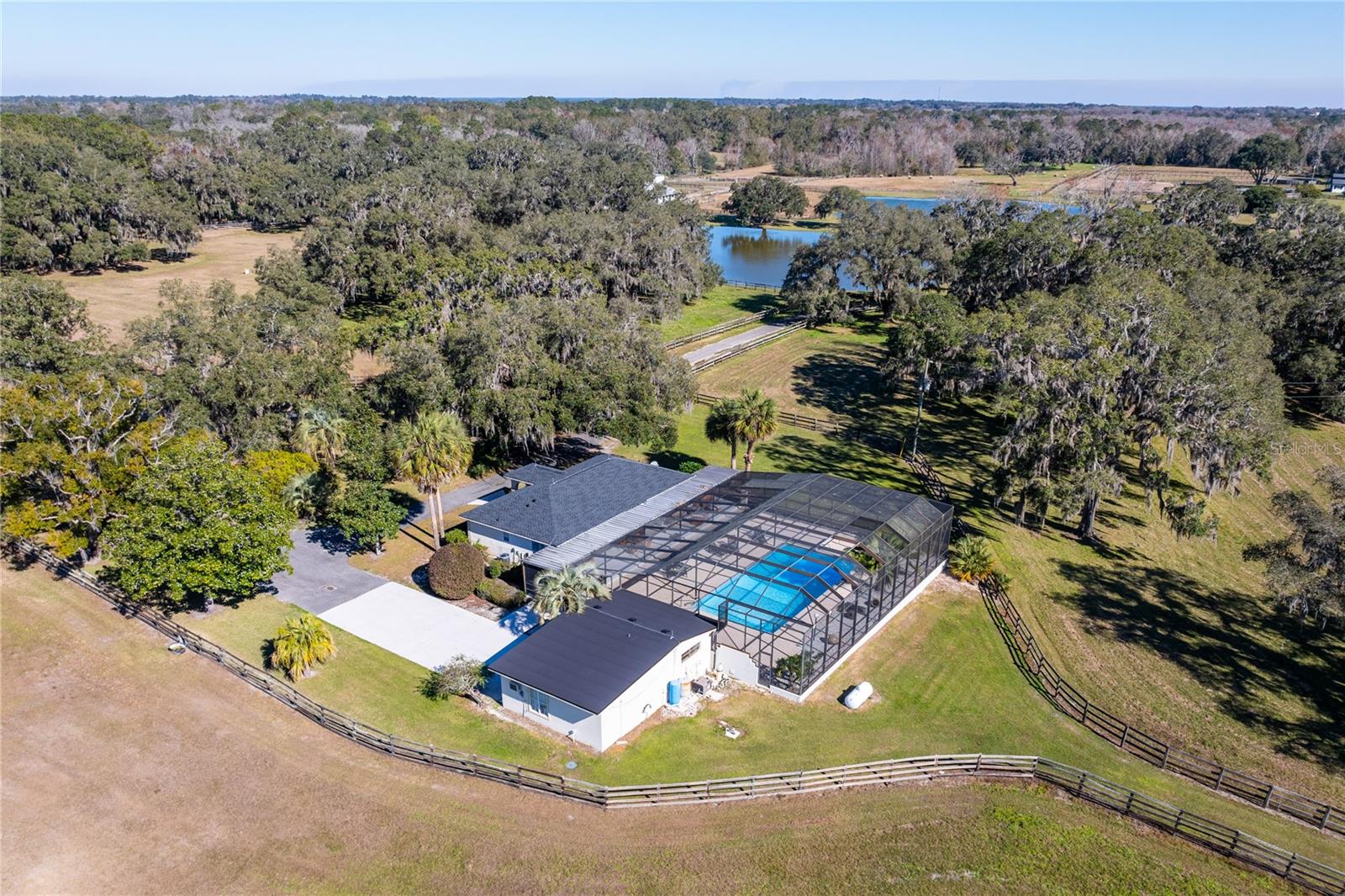 Welcome to a 125+/- acre breathtaking equestrian estate that captures tranquility, elegance, and privacy!  This magnificent farm is truly a rare find nestled off the renowned 225A Golden Corridor and just 12 miles from the World Equestrian Center.
Mature shade trees, lush green pastures, and gently rolling land, this property provides an idyllic setting for equestrian enthusiasts and those seeking a tranquil rural lifestyle. The extensive equestrian amenities include: Three Well-Appointed Barns:   An impressive 18-stall show stable complete with two grooming stalls, an office, tack and feed rooms, a laundry room, an outdoor sitting area, and an upstairs 1-bedroom, 1-bath apartment. It is located adjacent to the grass jumping ring, the lit sand ring, the Eurosizer, round pens, and the turnout paddocks.  A second barn featuring 23 stalls, a grooming stall, wash stalls, and a comfortable 3-bedroom apartment.   A third barn features 6 stalls, an outdoor wash stall, and a breakroom to accommodate your staff. 
You'll also enjoy a spacious main residence that boasts 3 bedrooms and 2 baths, designed with a screen-enclosed pool, plus a separate 1-bedroom, 1-bathroom guest apartment, making it ideal for family or visitors. As an added bonus, this property includes a generous 4-bedroom, 2-bath staff house, and 2 RV Hook-ups, ensuring you have everything needed for a seamless operation. 
Experience the serenity of nature with three picturesque lakes that enhance the charm of this exceptional property.  This turnkey equestrian estate is a dream come true for horse lovers and those seeking a private sanctuary with top-tier amenities. Don't miss this unique opportunity to own a piece of paradise! Schedule your tour today and step into a life of luxury and tranquility!