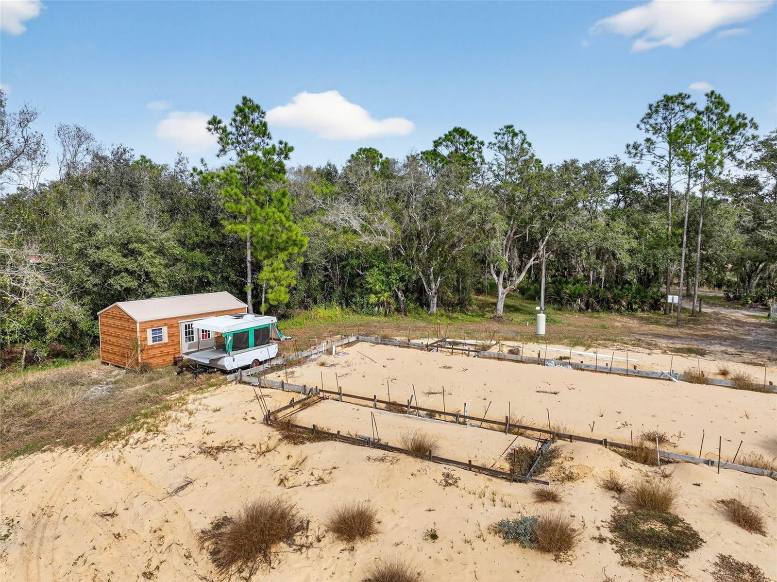 Rare opportunity to own 4.67 acres with creek access on Walk In Water Creek in Lake Wales, complete with a new artesian well, paid impact fees, and over $50,000 in upfront improvements already handled. Featuring 205 ft of Creek Frontage. New 12x24 shed and House plans for a 3-bedroom, 2-bath, 1,980 sq ft home are included, and the foundation is already started—saving valuable time and money. Whether you're an investor or builder seeking a shovel-ready project, or a buyer ready to build your dream home in a peaceful setting, this property offers unmatched flexibility: continue with the current plans or bring your own vision. With no HOA, a private setting, survey and elevation report included, and eligibility for FHA, VA, or USDA construction-to-perm financing, this is a truly rare and ready-to-go opportunity. Seller is also willing to throw in a 24x24 metal barn ready to be installed with the sale for a full asking offer. You can't ask for more than that!
