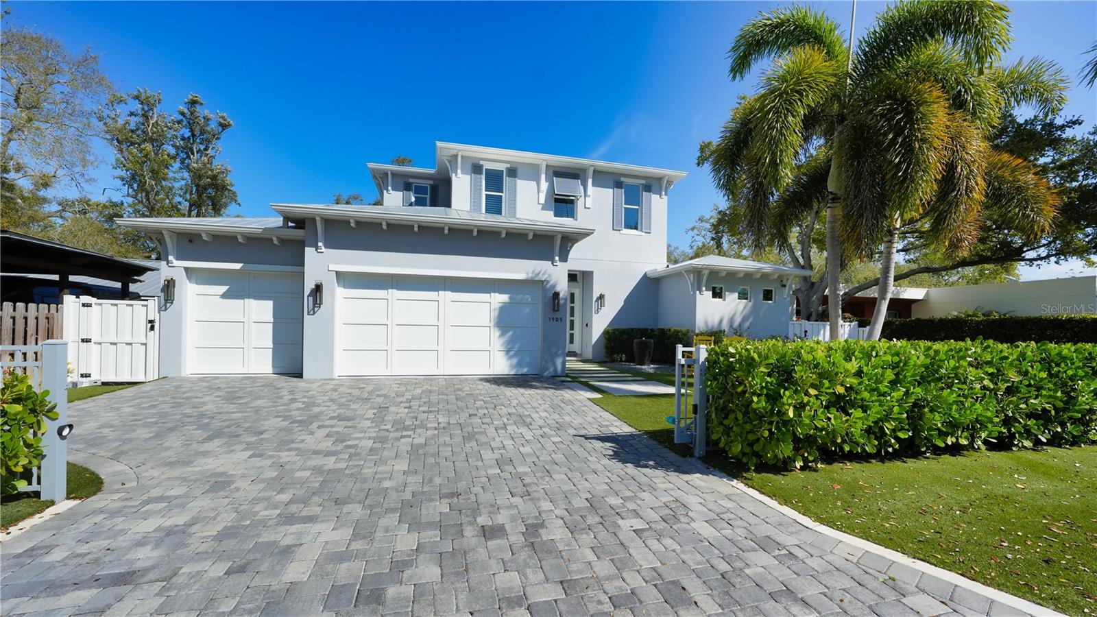 Discover the pinnacle of contemporary, eco-conscious living in this newer-built, energy-efficient home nestled West of the Trail. Classic Homes by Clayton Inc. has masterfully crafted this modern marvel, setting new standards in sophisticated, yet comfortable living spaces. Situated in a family-friendly neighborhood that offers the serenity of suburban life alongside easy access to Sarasota's bustling cultural scene, this home embodies the ultimate Gulf Coast lifestyle. Upon arrival, professional landscaping and a paved driveway lead you through a secure entry gate, hinting at the modern style that lies within. Spanning nearly 3,200 square feet of living space, this residence showcases the lavish benefits of new construction, where every detail is a testament to quality and eco-friendly design. Features such as Energy Star green certified construction, vinyl insulated impact glass windows, LED lighting, and high-efficiency appliances contribute to its sustainable footprint, while solid-core doors, plantation shutters, and custom cabinetry add layers of luxury. The home welcomes you with a contemporary open-concept layout, anchored by a gourmet kitchen that seamlessly transitions into a spacious great room and dining area. Pocketing sliders open to an expansive outdoor living space, designed as a private resort oasis. Here, a summer kitchen equipped with a grill, sink, and under-counter refrigerator invites alfresco dining against a backdrop of a custom heated swimming pool with a dramatic waterfall, sun shelf, fire pits, and LED lighting, all complemented by a raised spa for ultimate relaxation. The primary suite, conveniently located on the main level, offers a serene retreat with direct access to the patio. Highlights include his and hers oversized walk-in closets, abundant natural light, and a sleek en-suite bathroom. The additional guest bedroom on this floor doubles as a gym. Upstairs, a dedicated family room with a wet bar and two bedroom suites—one currently utilized as an office—ensure privacy and comfort for guests. Living here places you minutes from the charm of Southside Village Shops and Morton's Plaza, offering an array of boutique shopping and dining experiences. Downtown Sarasota's vibrant activities and scenic Bayfront are within easy reach, along with the Main Street farmers market for those weekend outings. Moreover, the home's proximity to Siesta Key, Lido Key, and Longboat Key means that some of the region's most exquisite Gulf beaches are just a short drive away, completing this exceptional lifestyle offering. Bedroom Closet Type: Walk-in Closet (Primary Bedroom).