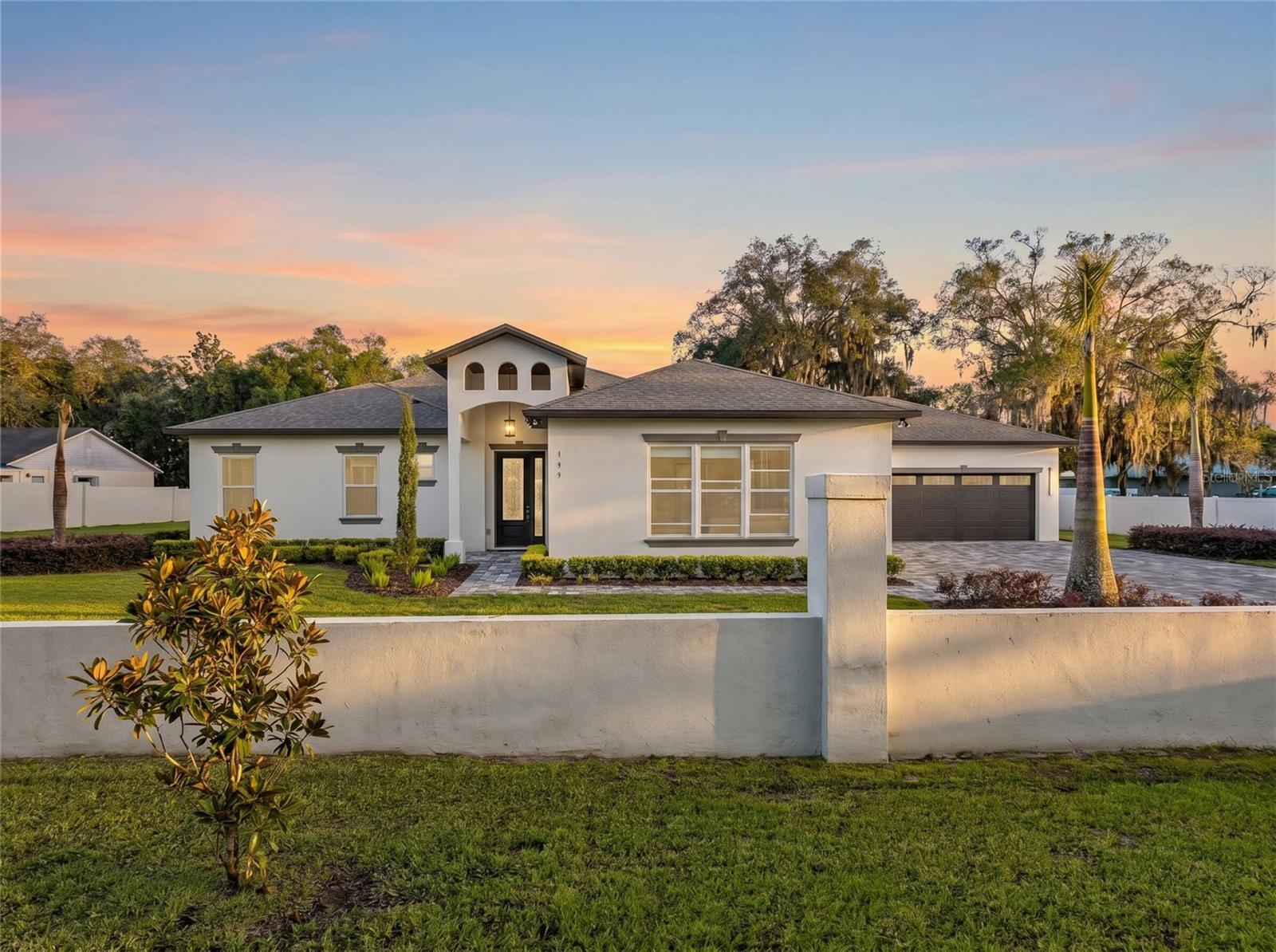 Welcome to your private slice of Central Florida. Situated on 1.25 fully fenced acres with no HOA, this custom-built home offers the perfect combination of luxury, privacy, and flexibility. With four garage spaces, oversized bedrooms, soaring ceilings, and premium finishes throughout, this property is ideal for buyers seeking room to spread out, entertain, or accommodate multigenerational living.

The open-concept floor plan features porcelain tile flooring, 12-foot tray ceilings, and a chef's kitchen complete with quartz countertops, a full-height quartz backsplash, a large half-moon island, soft-close cabinetry, cooktop, dishwasher, and a spacious walk-in pantry. The split-bedroom layout offers exceptional privacy. The primary suite features a tray ceiling, an oversized walk-in closet, dual granite vanities, a private water closet, and a spa-inspired walk-in shower with dual shower heads. A secondary bedroom includes its own en-suite bath and walk-in closet, while two additional oversized bedrooms each feature walk-in closets and share a full guest bathroom. A half bath is conveniently located off the main living area.

Step outside to a covered tiled lanai featuring a fully equipped outdoor kitchen with a built-in wine refrigerator overlooking the expansive cleared backyard. The 1.25-acre homesite provides ample room to add a custom pool, accessory dwelling unit (ADU), workshop, or create the backyard retreat you've always envisioned, subject to county approval.

Additional features include an attached two-car garage plus a detached two-car garage, impact-rated double-pane windows, architectural shingle roof (2023), water softener system, sprinkler system, spacious laundry room, septic system, and a chicken coop that conveys with the property.

Conveniently located near SR-429 with easy access to Orlando, Winter Garden, Mount Dora, shopping, dining, parks, and recreation, this exceptional Apopka home offers the rare opportunity to enjoy luxury living with acreage, no HOA, and endless possibilities. The property is also located near the site of the proposed Dynasty Sports & Entertainment District, a planned mixed-use destination expected to bring future sports, dining, retail, hospitality, and entertainment opportunities to West Orange County.