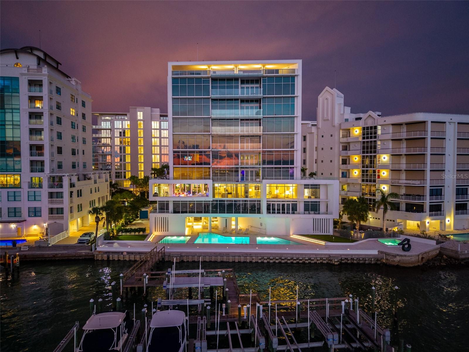 Experience extraordinary waterfront living in this stunning residence, where breathtaking panoramic views of Sarasota Bay take center stage. Designed by renowned architect Guy Peterson, this exceptional condominium is a true work of art, thoughtfully crafted for sophisticated living and perfectly suited for showcasing an extensive art collection. From the moment you enter, you're greeted by mesmerizing bay views framed by a dramatic Murano glass chandelier, creating an unforgettable first impression. The expansive great room features custom built-ins and an elegant entertaining bar complete with a Sub-Zero beverage refrigerator, making it ideal for hosting guests. A secondary bar equipped with Miele dishwasher, Wolf warming drawer, two refrigerated beverage drawers, microwave, sink and Sub Zero icemaker make hosting large events easy. Electronic blinds throughout the home provide effortless privacy and light control while complementing the residence's clean, contemporary aesthetic. The chef's kitchen is as beautiful as it is functional, offering two oversized islands, dual sinks, Sub-Zero refrigerator and freezer, a Wolf range, Wolf double wall ovens, a Miele dishwasher, striking tempered glass backsplash, and quartz countertops. Every detail has been carefully selected, and the spectacular Sarasota Bay views provide an inspiring backdrop while cooking. The owner's suite embodies Guy Peterson's signature minimalist elegance, with floor-to-ceiling views of Sarasota Bay and an extraordinary custom-designed walk-in closet with a view of the water that is truly one of the finest in Sarasota. The spa-inspired bath is equally impressive, featuring dual vanities, a marble walk-in shower with rainhead and handheld fixtures, and a soaking tub perfectly positioned to enjoy the tranquil waterfront views. Three additional ensuite guest bedrooms provide luxurious accommodations for visitors. Completing the home are a handsome office with custom built-ins and fitness room. The exceptionally large terrace which is the largest in the building,  provides ample seating for friends and family, and is outfitted with a large fire pit offering the perfect setting to relax and take in spectacular sunsets over Sarasota Bay. Dock with a 16,000-pound boat lift included with the home. This is a rare opportunity to own an architecturally significant waterfront residence where timeless design, exceptional craftsmanship, and world-class views come together in perfect harmony. Owners enjoy gated entry, a private two-car garage, concierge-staffed lobby, and an impressive collection of amenities including fitness center, yoga room, sauna, wine storage, executive meeting space and a stunning rooftop terrace with panoramic bay, gulf and skyline views. Ideally located on Golden Gate Point, just moments from downtown dining, arts, and marinas.