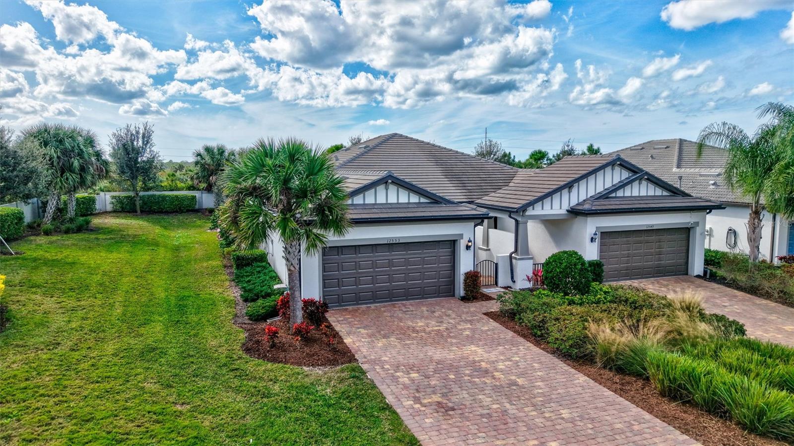Finally - this is the one you have been waiting for! This stunning 2021 Cressida model offers Impact Windows & Doors, extensive upgrades inside & out, and an exceptional end-of-the-cul-de-sac location that provides rare privacy. Designed to live like a single-family home, it features a 24-ft Courtyard entry & an impressive 29-ft extended covered lanai overlooking a tranquil, natural Florida backdrop. This open, light-filled floor plan features 9-ft ceilings, 8-ft interior doors, & abundant windows only an end-unit can provide. Easy-care porcelain tile & crown molding throughout complement the coastal-inspired, light-toned finishes. At the heart of the home, the Chef’s kitchen delights with a natural gas 5-burner range, 42-inch solid-wood cabinetry with soft-close drawers & pull outs, granite countertops, upgraded stainless appliances, under-cabinet lighting, a large pantry, and an island with extra storage & breakfast bar seating – perfect for everyday living or entertaining.  The gracious living area flows seamlessly through stacking sliders to the extended, pavered, covered and screened lanai for your private outdoor retreat.  The luxurious primary Ensuite is a true oasis, offering comfort-height granite counters, double undermount sinks, upgraded fixtures, and enlarged walk-in shower, separate linen storage and oversized walk-in closet & a private water closet. A versatile flex room allows you to personalize the space to your lifestyle, while the separate laundry room and mud-room entry from the 2-car garage add thoughtful convenience. Located in a maintenance-free, gated community, you’ll enjoy Resort-Style Amenities including a Clubhouse, Barefoot Bar, heated Pool & Spa, fitness center, pickleball, tennis, bocce ball, fire pit, fishing pier & an on-site Property Manager. Furry family members are welcome too, with a 2-sided dog park for both large & small pups. All of this with easy access to Downtown Sarasota’s cultural attractions, charming Downtown Venice, world-famous beaches and the 20+ mile Legacy Trail. Don’t miss the opportunity to see this value-priced, move-in-ready home!