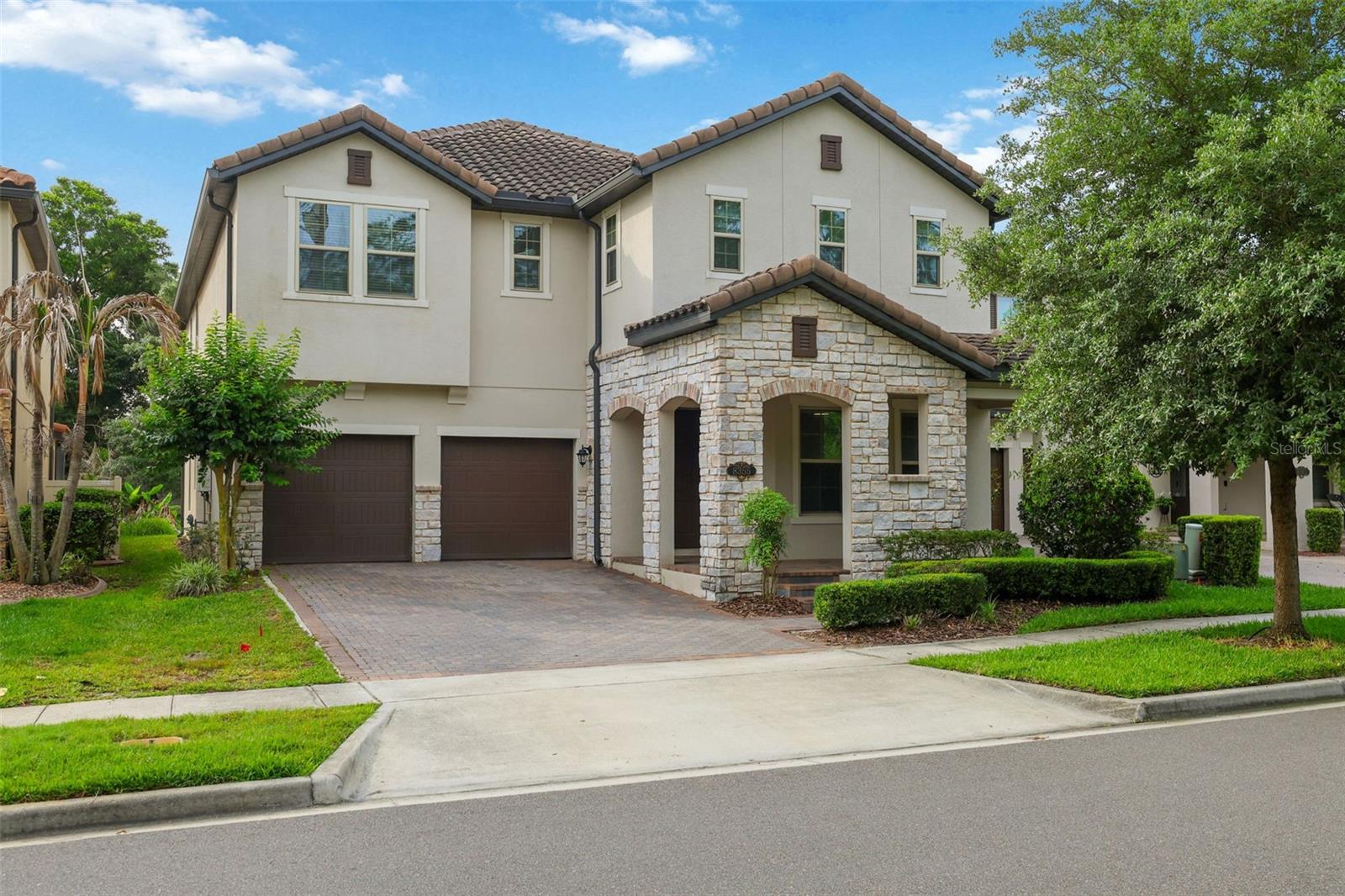 One or more photo(s) has been virtually staged. *Seller offers $20,000 credit to buyer at closing towards closing costs and pre-paids with acceptable offer* Experience luxury living in the highly sought-after “Cascade” floor plan, featuring an upgraded stone-accented exterior and tile roof in the desirable Windermere Isle community. Situated on a premium oversized lot with a HUGE backyard and mature trees for added privacy, this exceptional home offers the perfect blend of relaxation, comfort, and entertainment. Enjoy peaceful conservation views from the charming front porch, while the rear of the home provides enchanting nightly views of Disney fireworks lighting up the sky. Inside, meticulous attention to detail is evident throughout this thoughtfully designed home. The main level features two bedrooms, including one ideal for a home office with double entry doors and a walk-in closet. The dream kitchen showcases upgraded cabinetry with crown molding, Quartz countertops, gas cooktop, upgraded double convection wall ovens, upgraded French door refrigerator, a generous walk-in pantry, and a convenient 7’ x 5’ pocket office complete with built-in desk and cabinetry. Wood-look tile flows throughout the downstairs living areas, complemented by engineered hardwood flooring in the dining room and great room. A functional drop zone near the garage includes upgraded lower cabinetry topped with Quartz counters. Beautiful wood stairs lead to the second floor, where you’ll find a sprawling loft/bonus room, spacious media/game room and an oversized laundry room equipped with washer, dryer, and laundry sink. Additional highlights upstairs include a half bath, abundant storage closets, and two secondary bedrooms with walk-in closets connected by a Jack-and-Jill bath. The luxurious primary suite is a true retreat, featuring a tray ceiling and stunning nightly Disney fireworks views. The spa-inspired primary bath offers a large soaking tub, an oversized walk-in shower with upgraded glass enclosure, dual vanities, and an expansive 13x12 walk-in closet. Additional features include 8-foot doors throughout, ceiling fans in all bedrooms, LED lighting and a natural gas tankless water heater for ultimate convenience and efficiency. Vinyl fencing is already installed on three sides by neighboring properties. HOA includes lawn maintenance and 1 GIG Spectrum internet and cable with 4-5 streaming choices. Community pool, playground and walk path around scenic pond. Ideally located with convenient access to shopping, dining, entertainment, and major roadways, this remarkable home perfectly combines luxury, functionality, and everyday comfort. Don’t miss the opportunity to make this extraordinary property your own — schedule your private tour today!