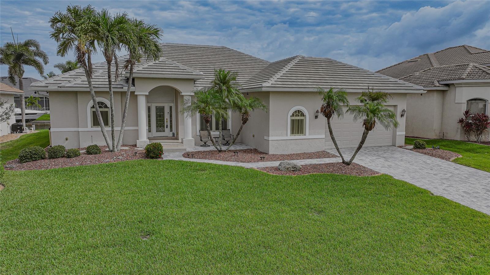Beautifully designed waterfront home in the highly desirable community of Burnt Store Isles, offering 2,373 square feet of living space, 3 bedrooms, 2 bathrooms, and an oversized garage with workshop. Situated on 82 feet of city-maintained concrete seawall, this property boasts exceptional wide canal views and quick sailboat and power boat access to Charlotte Harbor and the Gulf. Boaters will appreciate the 10,000-pound boat lift, installed in 2020, making it easy to enjoy Southwest Florida's premier boating and fishing destinations.
This Partially Furnished residence features a formal living room, separate dining room, large family room floor plan with vaulted ceilings, plantation shutters, and abundant natural light throughout. Pocketing sliding glass doors seamlessly blend indoor and outdoor living, opening from the formal living room and inviting family room to the expansive lanai and pool area. The breakfast nook showcases an aquarium window that maximizing the canal views.
The spacious kitchen is designed for both everyday living and entertaining, featuring granite countertops, raised-panel cabinetry, tile backsplash, breakfast bar, closet pantry, and stainless steel appliances.
The private primary suite is a relaxing retreat with direct access to the lanai through sliding glass doors, dual walk-in closets, dual vanities, a private water closet with newer toilet, garden tub, and separate walk-in shower. A split-bedroom floor plan provides privacy for family and guests with two additional bedrooms and a full guest bath located on the opposite side of the home.
Outdoor living is truly exceptional with a resurfaced heated pool featuring a water feature and self-cleaning system, a covered lanai, outdoor shower, and panoramic no-see-um screens that maximize the stunning water views. There is also an outdoor seating area with electrical in place for a future hot tub, creating the perfect setting for entertaining or relaxing under the Florida sunshine.
Recent updates include New Interior Paint (2025), New Tile Roof (2023), Resurfaced Pool (2023), New Pool Heater (2024), Paver Driveway and Lanai (2025), Water Softener (2020), and Water Heater (2024), and Complete Hurricane Protection for peace of mind.
The deed restricted waterfront and golf course community of Burnt Store Isles is also conveniently located within close proximity to famous Fishermen’s Village, the new Sunseeker Resort, major highways and airports, and just a few minutes to downtown Punta Gorda, where you can enjoy its unique restaurants, shopping, pickle ball, biking, and waterfront activities. Optional membership at the nearby Twin Isles Country Club is also available. This exceptional waterfront residence offers the perfect combination of comfort, and the coveted Florida boating lifestyle.