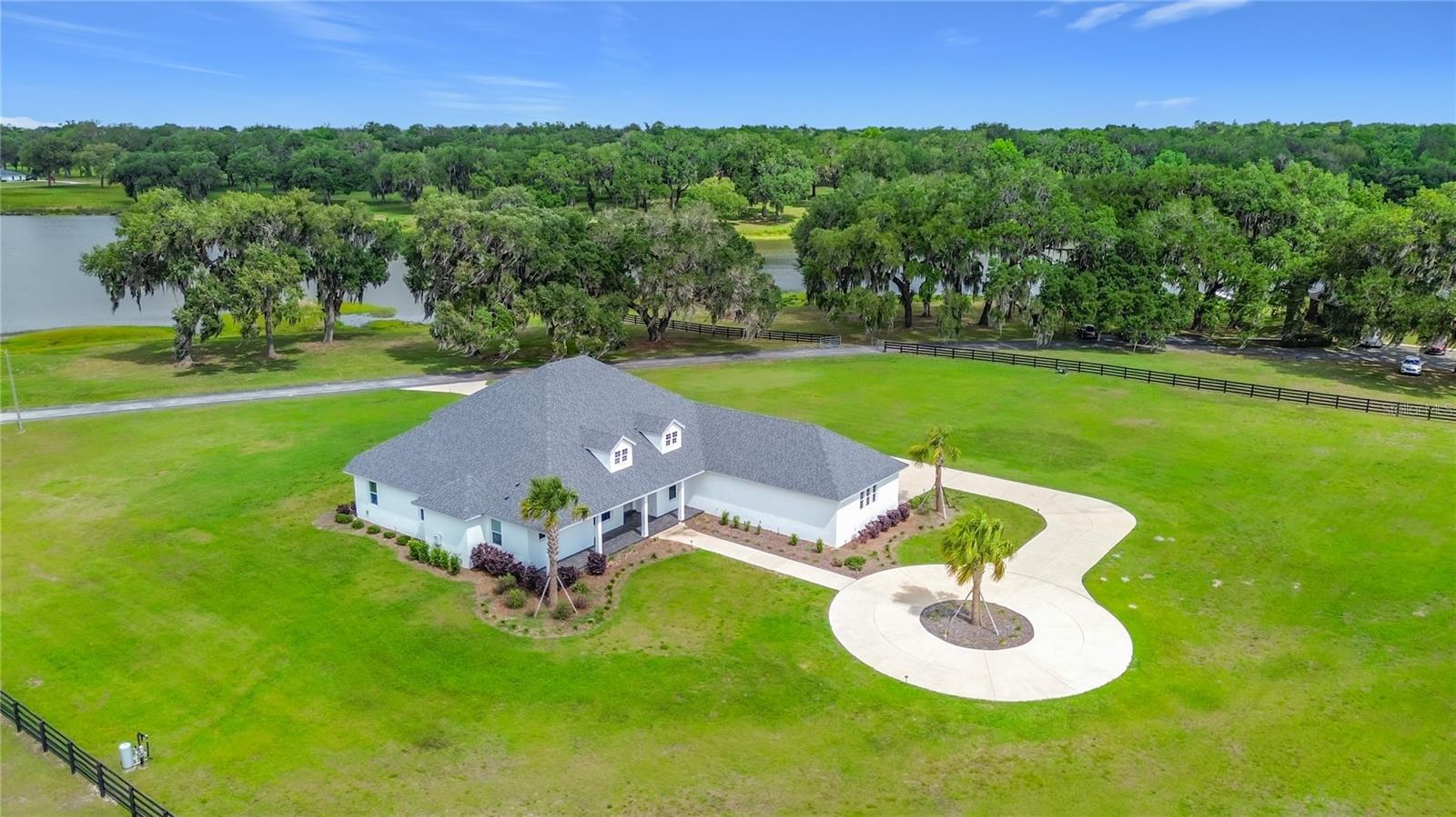 A rare legacy equestrian estate in the heart of Florida horse country, this extraordinary Silverleaf Hills property offers nearly 43.65 acres of rolling, fenced pasture crowned by a nationally recognized, iconic hilltop barn and breathtaking views of a spring-fed Lake Padua. Ideally positioned just minutes from the World Equestrian Center (WEC) and HITS Ocala, the estate places elite competition, training, and breeding at your doorstep while preserving the serenity of a private nature preserve. The historic barn—once home to Silverleaf Farm and Padua Stables—is thoughtfully designed for any equine discipline with 19 oversized 12x12 stalls, two double foaling stalls, tack and feed rooms, loading ramp, 6+ lush paddocks, a dedicated office with 1 full bathroom and a center isle half bath. The stables are complete with a fully remodeled 42x200 barndominium featuring a refined living area, 1 bedroom 1 bathroom, large kitchen with granite counters and premium appliances and a new roof (2021). The custom CenterState residence with 4 bedrooms and 3 baths has never been lived in and embraces luxury and function with expansive indoor-outdoor living, a summer kitchen, gas fireplace, office/den, guest suite, Generac generator, dual septic systems, private wells, wired security system, and a spa-like owner’s bath with steam shower, all set within the 738+ acre gated, deed-restricted Silverleaf Hills community of majestic oaks, rolling hills, three lakes, abundant wildlife, and unforgettable sunrises and sunsets—offering the rare feeling of secluded equestrian elegance just minutes from shopping, dining, medical facilities, and The Villages.