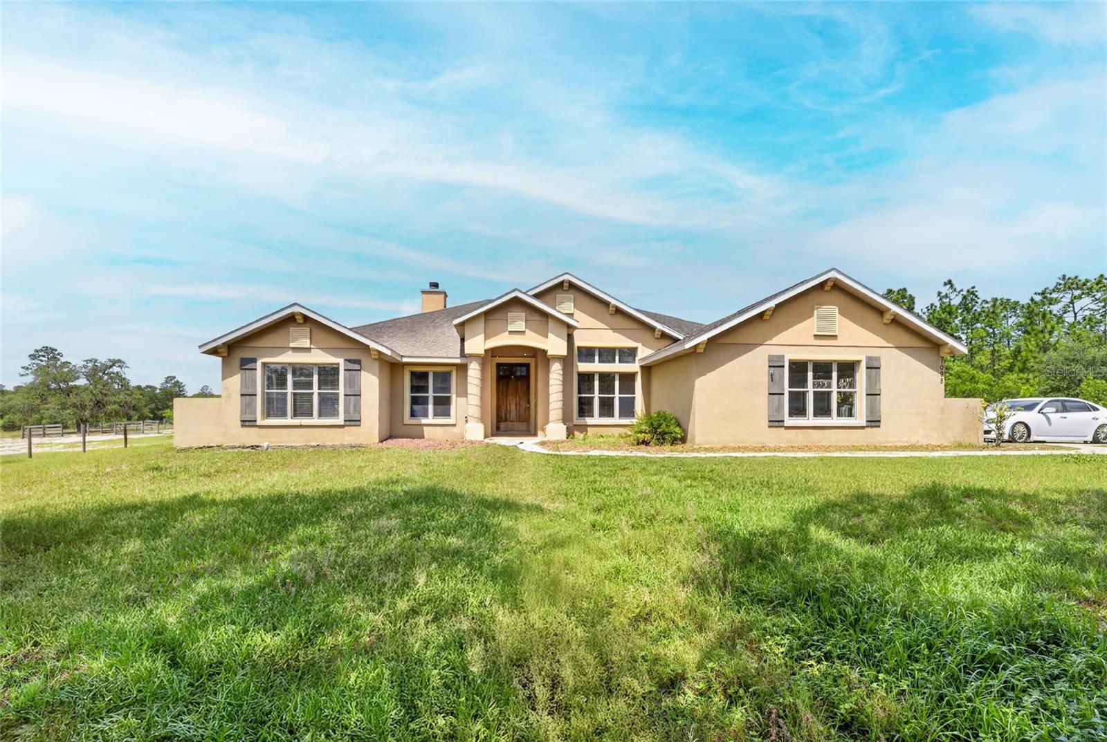 One or more photo(s) has been virtually staged. Exceptional 10-acre equestrian property located just 10 minutes from the World Equestrian Center. This 3-bedroom, 2-bath home with a dedicated office offers 2,232 square feet of thoughtfully designed living space featuring a gourmet granite kitchen with an oversized island, abundant cabinetry, and generous entertaining areas. The open-concept living room is enhanced by a wired surround sound system and seamlessly connects to the outdoor living space through triple sliding glass doors that fully open to an expansive screened lanai. Enjoy year-round outdoor living with a heated and cooled saltwater pool, spacious pool deck, and fully equipped summer kitchen, creating the perfect setting for gatherings with family. The private property is equipped for equestrian enthusiasts with a separate entrance, pole barn featuring four stalls, five paddocks, and ample room for horses and agricultural pursuits; the barn is also fully equipped with electric and water for added convenience. Offering privacy, functionality, and an unbeatable location near Ocala's premier equestrian destination, this is a rare opportunity to own a farm property with all the features needed for comfortable country living. AC is 2021, “NEW ROOF” prior to closing with acceptable offer! Schedule your private tour today!
