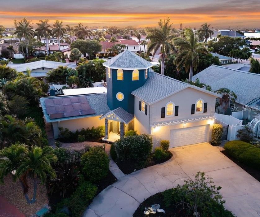 Welcome to your private island retreat, tucked away on a quiet cul-de-sac in one of Tierra Verde's most desirable neighborhoods. This exceptional POOL HOME blends MULTI-GENERATIONAL LIVING, ENERGY EFFICIENCY, and the Florida lifestyle you've been dreaming of.

Featuring 4 BEDROOMS, 3 BATHROOMS, and a 2-CAR GARAGE, the flexible split floor plan includes two bedrooms on the main level and two upstairs. The spacious upstairs retreat is ideal as a SECOND PRIMARY SUITE, PRIVATE GUEST QUARTERS, or IN-LAW SUITE, complete with pre-plumbing for a kitchenette and washer/dryer hookups. The downstairs primary suite features a spa-inspired STEAM SHOWER, while the adjacent bedroom and bath offer the opportunity to create an expansive LUXURY PRIMARY SUITE.

The inviting living room showcases a dramatic stone accent wall with a WOOD-BURNING FIREPLACE, while the chef's kitchen is equipped with NEWER STAINLESS STEEL APPLIANCES, a WINE REFRIGERATOR, and pull-out refrigerator drawers.

Step outside to your private tropical oasis featuring lush landscaping and a sparkling POOL, perfect for year-round entertaining and relaxation.

A standout architectural feature is the charming CRAFTSMAN-INSPIRED TURRET, leading to a unique third-floor lookout surrounded by windows—ideal as a HOME OFFICE, studio, or peaceful retreat.

Enjoy peace of mind with major updates including a NEW ROOF (2025), FULLY PAID-OFF SOLAR PANELS with electric bills averaging under $40/month, TWO A/C SYSTEMS (2020 & 2023), and a TANKLESS WATER HEATER.

Located just minutes from marinas, waterfront dining, downtown St. Petersburg, and only 3 miles from Fort De Soto Park, you'll enjoy award-winning beaches, boating, kayaking, fishing, biking, and nature trails right outside your door. This is a rare opportunity to own an energy-efficient island home in one of Tampa Bay's most sought-after waterfront communities.