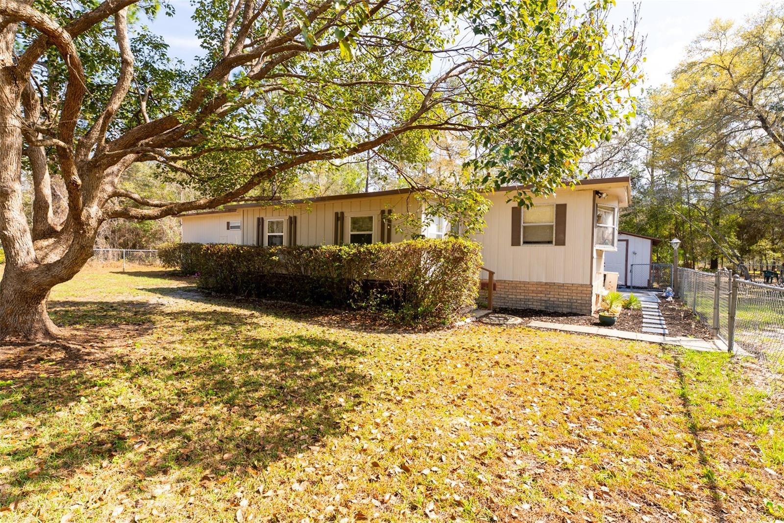 Peaceful Country Living on Nearly an Acre. 
Welcome to your own little slice of peaceful country living! This cozy 2 bedroom, 1 bath home sits on almost an acre of beautifully cleared land with mature landscaping and is fully fenced, offering both privacy and room to roam. The unique road-to-road property provides convenient access and a wonderful sense of space.
Enjoy quiet mornings or relaxing evenings on the screened porch, surrounded by the sights and sounds of nature. Outside, you'll find storage buildings, a carport, and a charming fire pit area—perfect for gathering with family and friends under the stars.
Inside, the home feels warm, comfortable, and inviting, making it easy to settle in and feel right at home. With beautiful natural surroundings all around you, you'll love the peaceful setting while still being close to the river, nearby shopping, and just a short 20-minute drive to Ocala. Come enjoy the simple pleasures of nature, privacy, and space—this property is ready to welcome you home.
