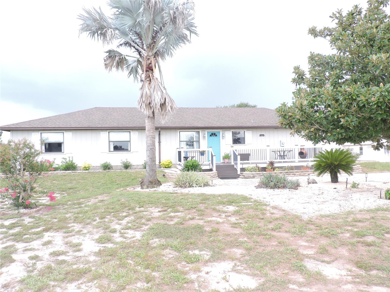 Welcome home to this beautifully maintained 3-bedroom, 2-bathroom ranch on 7.54 M/L acres of picturesque, fully fenced land!
From the moment you arrive, this home makes an impression — a welcoming front porch with white railing, a cheerful teal front door, and mature landscaping with palms and shade trees set the tone. Inside, you’ll find a bright, open floor plan where the kitchen, dining, and living areas flow effortlessly together. The updated kitchen features crisp quartz-style countertops, freshly painted cabinetry, and a large wraparound breakfast bar with seating — perfect for entertaining or casual family meals. The spacious living room is filled with natural light from sliding glass doors that open to a screened lanai, where you can relax and take in sweeping views of your own green pastures and majestic oaks. The oversized primary suite is a true retreat, offering room for a sitting area, built-in shelving, and beautiful wood-look flooring. Two additional bedrooms and a second full bath provide comfortable space for family or guests. 
Now for the horse lover’s dream:
Step outside to your very own equestrian setup! The property boasts a 5-stall wood stable with a classic green metal roof, covered walkway, and a fully powered tack room for all your gear. Above, a two-story hay loft offers generous storage for feed, hay, and supplies. Board fencing and cross-fenced pastures surround the property, giving your horses safe room to roam and graze under the shade of mature oaks. A detached outbuilding provides even more storage or workshop potential. All of this in a peaceful country setting, just minutes from Bartow’s shops and dining, with easy access to Lakeland, Winter Haven, and the greater Central Florida area. Turnkey equestrian properties like this don’t come along often — schedule your private showing today!