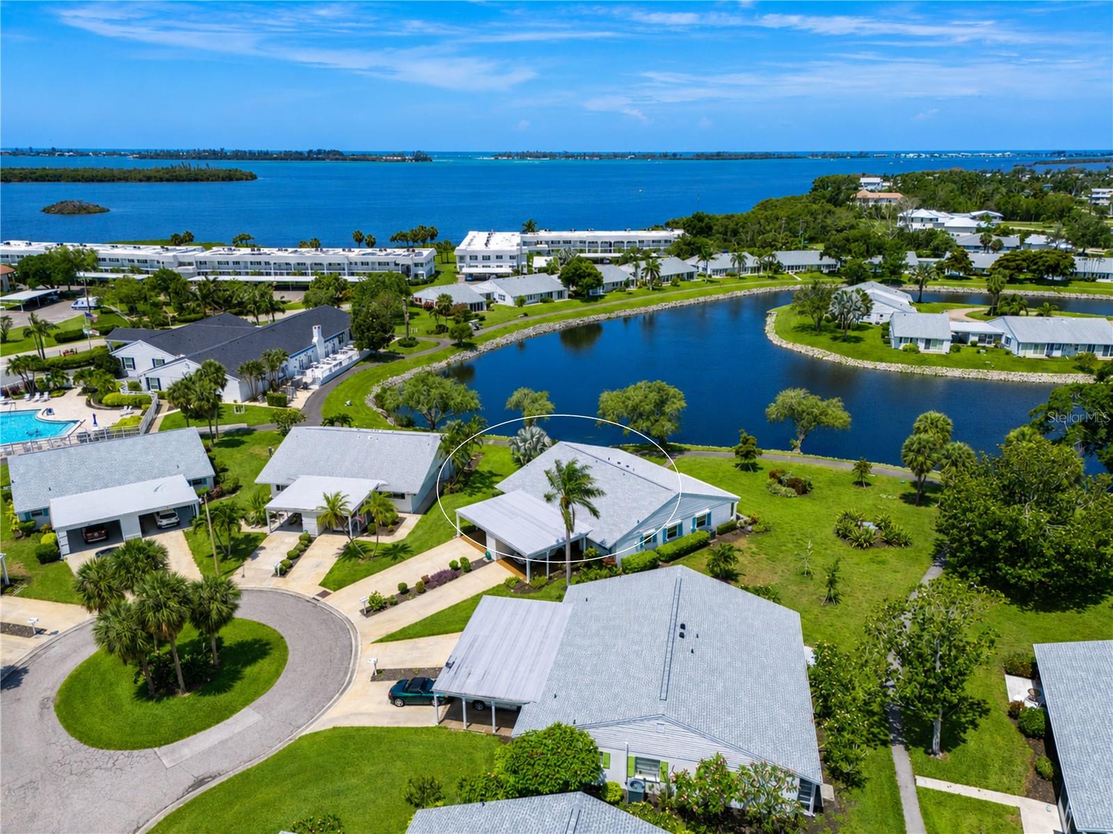 PERFECTLY POSITIONED ON A PEACEFUL LAKEFRONT CUL-DE-SAC in a vibrant bay front community just steps from the clubhouse and amenities, this beautifully maintained move-in ready single-level villa combines comfort, convenience, and an active coastal lifestyle.
FROM THE MOMENT YOU ARRIVE, you'll appreciate the wide newer driveway, oversized carport with refreshed Poly-Pebble flooring, convenient ramp entry with railing, and 12' x 5' secure exterior storage room. A private lakefront paver patio provides the perfect place to enjoy morning coffee, evening sunsets, and abundant wildlife, while a sidewalk connects directly to the scenic walking path that meanders throughout the community. BUILT WITH DURABLE CONCRETE BLOCK CONSTRUCTION, this residence offers valuable peace of mind with a 2022 roof featuring third-nail roof-to-wall connectors for insurance savings, impact-resistant windows, storm shutters on the sunroom windows, and numerous thoughtful updates throughout. INSIDE, THE OPEN-CONCEPT FLOOR PLAN is bright, welcoming, and designed for effortless everyday living. The desirable split-bedroom layout provides privacy for owners and guests, while a pocket door creates a private guest suite when entertaining overnight visitors. Rich plank wood flooring flows through the living room, dining area, and bedrooms, complemented by tile flooring in the entry, kitchen, sunroom, and bathrooms. Plantation shutters throughout, coastal-inspired paint colors, recessed lighting, tray ceiling details, six-panel doors, and abundant natural light create an inviting atmosphere. THE BEAUTIFULLY UPDATED KITCHEN is both functional and stylish, featuring abundant wood cabinetry, granite countertops, stainless steel appliances including a convection oven, tile backsplash, diagonal tile flooring, coffee bar, organizational storage features, undercabinet lighting, and ample workspace for preparing meals and gathering with friends and family. THE SUNROOM serves as an extension of the living space, offering tranquil lake views and sliding doors that open directly to the paver patio, seamlessly blending indoor and outdoor living.
THE SPACIOUS PRIMARY SUITE includes a customized closet organization system and easy access to additional attic storage via pull-down stairs. The beautifully renovated primary bath features updated shower tile, corner shelving, safety grab bars, a semi-frameless glass enclosure, coordinating vanity, wall cabinetry, updated lighting, mirror, and fixtures. Guests will enjoy an equally impressive updated secondary bathroom. ADDITIONAL FEATURES include a Nest thermostat, extensive storage solutions throughout, and countless thoughtful details that make daily living easier and more enjoyable. ALL OF THIS is located within a vibrant waterfront community known for its beautiful grounds, active social calendar, and exceptional amenities. Whether you're seeking a year-round residence or a seasonal retreat, this lakefront villa offers the perfect combination of comfort, security, convenience, and Florida charm. COMMUNITY FEATURES remodeled clubhouse, banquet room, billiards, ping-pong, library/game room, lakeside veranda, boat docks, heated pool, tennis, pickleball, shuffleboard, bocce ball, spa, sauna, workshop, chip/putting green, walking paths, butterfly garden, bayfront park, kayak launch/storage, bayside pavilion, lakeside gazebo, bird sanctuary, tidal pond, many lakes, spacious grounds of nearly 90 acres teaming with Florida wildlife!