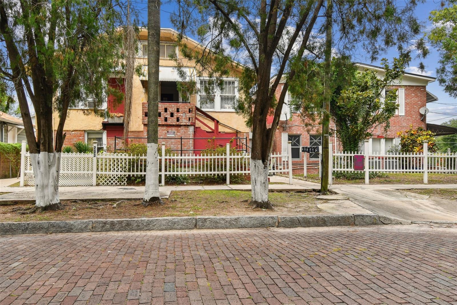 OPPORTUNITY ZONE: There are a total of 8 rental units in 4 buildings: 1 Single family-4 bedroom/2 bath, 2nd Single Family-2 bedroom/2 bath, 1 Apartment Building with 4 studio units plus TWO- 1 bedroom/1 bath units. Built in 1935, 1940, and 1946, these buildings reflect a rich history from a time when Tampa Heights blossomed into a vibrant community characterized by residential and commercial growth. Each unit and both homes are separately metered and tenants pay all utilities except water/sewer and small gas bill. This lot is 10,922 sq ft - zoned RM-24, and rich with redevelopment potential. Seller will consider financing with substantial down payment. 
This property has been treasured by the same family since 1960, serving as a beacon of hope and renewal for many. The owner has offered below-market rental rates, as a service in the community for the past 15 years. With some renovations, these stately residences have the potential to significantly increase the rental income.The property has great access on a corner and with an alley running along the north side. Conveniently located just a few blocks from Highland Park, the YMCA, Armature Works, and the scenic Tampa Riverfront Waterworks park, this property is also near Perry Harvey Sr. Park’s skatepark, a variety of shopping options, entertainment hubs, fine dining, as well as cultural and artistic venues. With easy access to Downtown Tampa, Ybor City, and Tampa International Airport, the location is ideal for both residents and investors. 
The property's size and location present a unique development opportunity in one of Tampa Bay's fastest-growing neighborhoods. As the area's progress continues, opportunities like this are becoming increasingly rare. Seller will consider financing with favorable terms.
Please respect the privacy of the current tenants—do not trespass or engage with them. Showings are available by appointment only, with a minimum 72-hour notice.