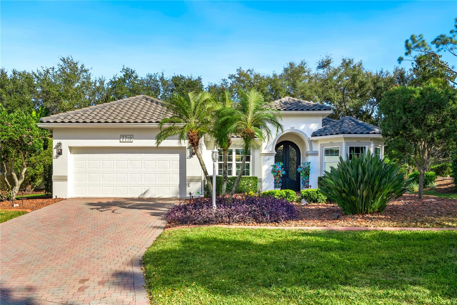 Extraordinary designer pool home showcasing over $750,000 in upgrades, this 2 bedroom, 2 bath residence offers 1,675 sq ft of impeccably curated living space where every detail has been thoughtfully selected from floor to ceiling. Truly a “must-see” smart home, blending elegance, technology, and comfort. From the moment you arrive, you’re greeted by designer iron arched front doors, lush tropical landscaping with stone accents and elegant lighting, and impact-rated windows and doors throughout. Inside, 24” x 48” porcelain tile floors, vaulted ceilings, wood-trimmed entryways, 8’ solid-core doors, crown molding, and 5¼” baseboards set the tone for refined living .The stunning, open-concept kitchen is a showpiece, featuring rich solid wood cabinetry with designer hardware, quartz countertops, a chair-height island, custom tile backsplash extending to the island front, buffet cabinetry, pantry with built-in coffee station and plumbed water line, pot filler, appliance lift, butcher-style stainless sink, soft-close drawers, and stainless steel appliances including a custom brass hood.
The great room impresses with a marble-accented TV wall, custom wall detailing, and sliders leading to the lanai. A beautifully crafted built-in highlights the dining area, while the den features a bay-style window with seating and storage plus custom ceiling detail.
The primary suite is a private retreat with sliders to the lanai, coffered ceiling, applied wall molding with designer wallpaper, customized walk-in closets, and a spa-like bath offering dual quartz vanities, decorative mirrors, linen tower, soaking tub with niche, and a luxurious shower with handheld controls compatible with Alexa. A mirrored “secret” door leads directly to the laundry from the primary suite. Outdoor living is exceptional with a rectangular heated saltwater pool, marble tile deck, stone columns, and lush landscaping creating a private resort-style setting.
Additional features include spray foam attic insulation, painted garage floors, overhead storage racks, pull-down attic stairs, garage refrigerator, shoe storage cabinet, four TVs (great room, primary bedroom, den, and lanai), safe in primary closet, and a hand-carved statue of David in the entry that conveys with the home. This gem is a “Wow” from floor to ceiling!