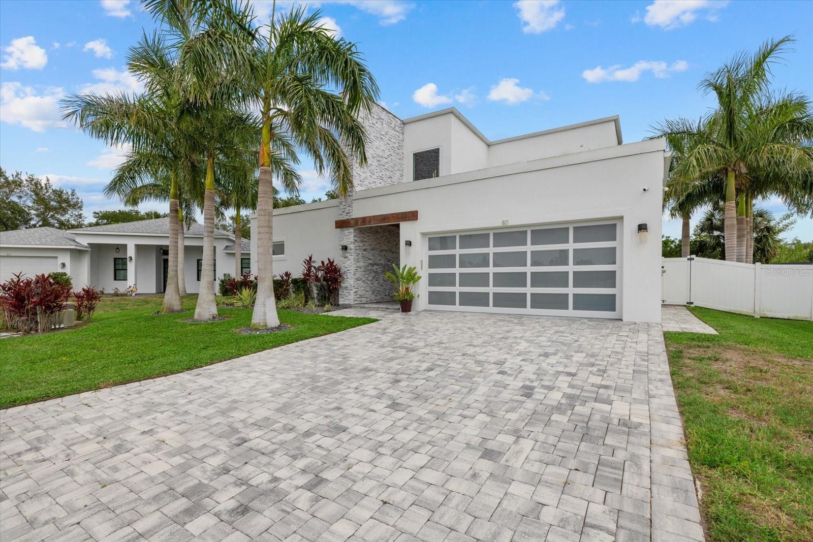 GULF ACCESS! DOCK & 13,000 LB LIFT! HEATED POOL! IMPACT GLASS! BUILT IN 2022! Positioned within the secluded small neighborhood of Hidden Lagoon, this modern waterfront residence delivers a private setting with a refined blend of architectural design, high-end finishes, and direct boating access, crafted for those who expect both style and substance. This thoughtfully designed home offers 3 bedrooms plus a dedicated office, 3 full bathrooms, and a layout that balances open concept living with private retreats. The primary suite, located on the first floor, is a true sanctuary, featuring sliding glass doors that open directly to the pool and lanai. The spa inspired ensuite showcases split vanities, frameless LED illuminated mirrors, a designer soaking tub, an expansive walk-in shower wrapped in floor-to-ceiling glass tile, a private water closet, and a custom walk-in closet with built-in shelving. At the heart of the home, the kitchen is appointed with premium VIKING appliances-including a refrigerator, range, and microwave and a Samsung dishwasher, complemented by sleek quartz countertops, an oversized island with additional storage, and a spacious walk-in pantry concealed behind a statement barn door. The living room is elevated by a wall of sliding glass doors that fully open to the covered lanai, creating a seamless indoor/outdoor living experience ideal for entertaining. The first floor also includes a versatile office/den/bonus room and provides flexibility for work or relaxation and is accompanied by a beautifully finished guest bath with a floor-to-ceiling tiled walk-in shower. The first-floor laundry room is equally well appointed with cabinetry, quartz surfaces, and a utility sink. A striking modern staircase with wood treads and black cable railings leads to the second level, where two guest bedrooms and a full bathroom with dual vanities and a glass-enclosed, floor-to-ceiling tiled shower provide comfortable accommodations for family or guests. Throughout the home, marble tile flooring enhances the clean, contemporary aesthetic. Outdoors, the property is designed to maximize the Florida WATERFRONT lifestyle. The covered lanai is equipped with Storm Smart screens (installed in 2024) and overlooks a HEATED POOL measuring approximately 11' x 25’, surrounded by pavers that extend seamlessly from the driveway. The pool is supported by a premium PENTAIR system, including a Pentair heater, ensuring efficient performance and year-round enjoyment. The professionally landscaped grounds feature 3 Royal Palms in front of the home and 11 Royal palms in the backyard, enclosed by a white vinyl fence for a PRIVATE RESORT like feel. For boating enthusiasts, the supersized private dock with Trex decking wraps around a COVERED 13,000 lb boat lift and includes both water and electric service—offering a short, direct route to the Manatee River and onward to the Gulf. Located in Hidden Lagoon, a unique community allowing SHORT TERM RENTALS with a 14-day minimum, this property presents exceptional flexibility for both personal use and investment potential. This is an excellent opportunity to own a nearly new, design-forward waterfront home that delivers luxury, functionality, and access to the very best of Florida living!