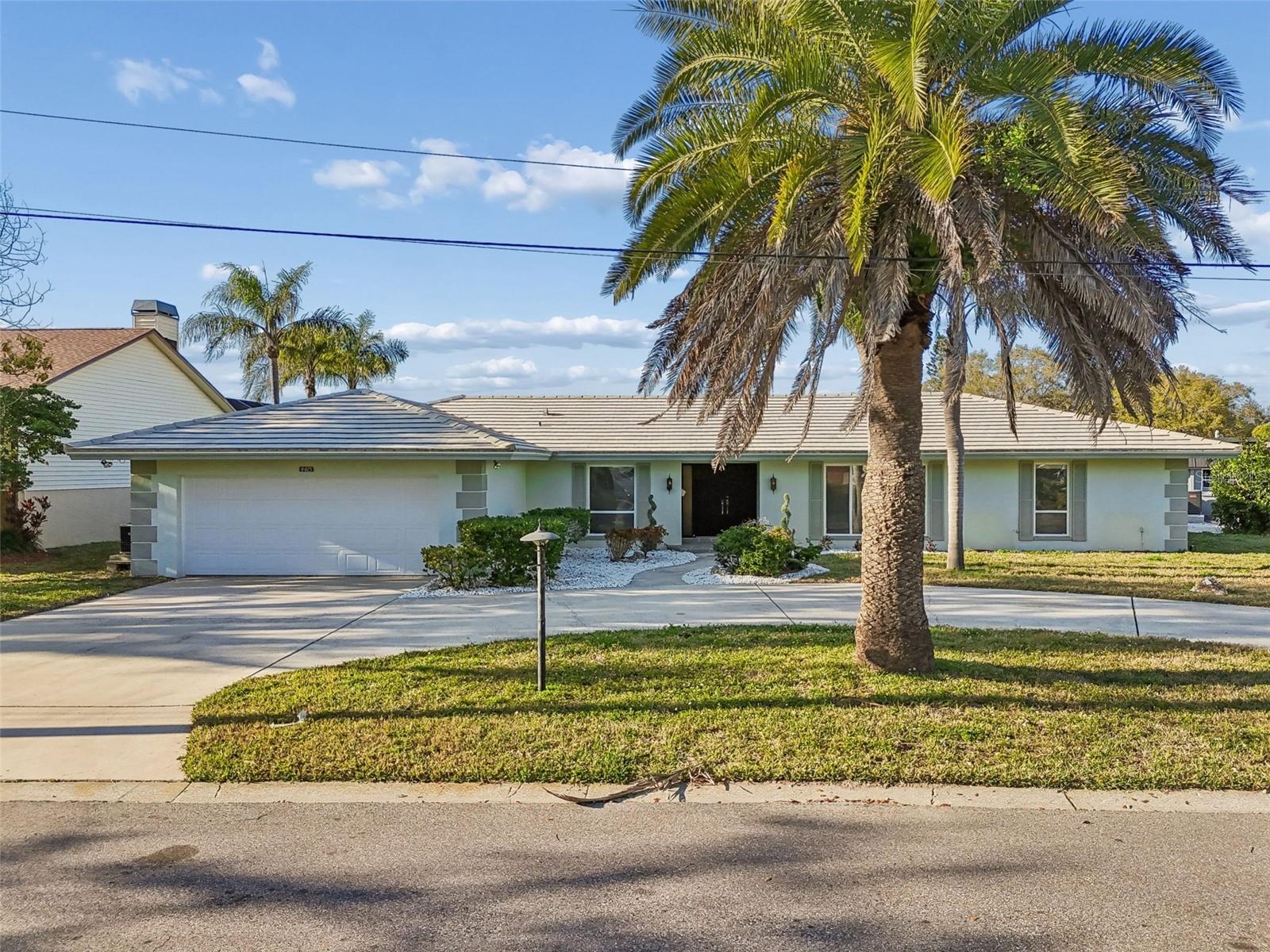 One or more photo(s) has been virtually staged. BOATERS BLISS... calling all boating, fishing, kayak, paddleboarding and jet-ski lovers! This canal-front residence, offered for the first time by the original contractor’s family, is on a large.32-acre corner lot, offering direct access to the Intracoastal. The newly replaced wood dock with davit extends 20 feet into the canal, providing several feet of water at low tide. It’s a short ride south to Largo Intracoastal Marina to fuel your boat, and a quick trip back north to the Clearwater Pass Bridge (72-foot clearance) and out into the Gulf. Join up with other boaters on Three Rookers Island and spend the day!                                                                                                                                              
This well-built home, slightly elevated above garage level, features a traditional Florida ranch-style home with a thoughtfully designed floor plan that provides separation and functionality. Office/4th bedroom is on one wing next to owner’s suite. Two bedrooms and bath provide privacy for guests/family on the other wing. Sliders open from the rear family room with a view through the covered lanai to the canal and dock. There have been some recent improvements. LVP flooring in living areas and bedrooms, and fresh interior paint. Both baths feature new tile floors, commodes, and shower tile. The kitchen was updated with new stainless steel GE appliances, quartz countertops and tile backsplash. The remainder of the home is waiting for your personal stamp.                                                                                                                   
This property is in an AE flood zone, and lender may require flood insurance. Home sustained minimal damage from Hurricane Helene. Additional features include an oversized two-car garage, a low annual homeowners association fee and a golf cart-friendly neighborhood. An amazing opportunity for a primary home, vacation getaway or investment property, this residence is priced for value and future potential.  Minutes from dining, shopping, Belleair Causeway Boat Ramp and sparkling beaches. Less than 30 minutes from Tampa Int'l Airport and 20 minutes from Clearwater/St Pete (PIE) Airport! Don't miss this opportunity to own a waterfront home in a desired community!