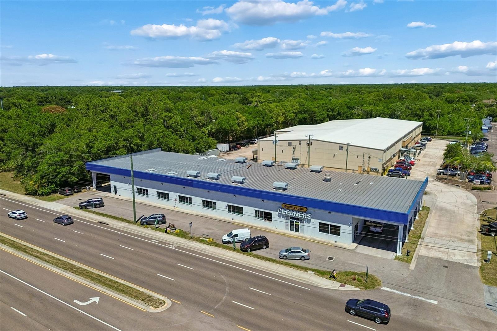 We are proud to present for sale 9945 Racetrack Road (the “Property”), a rare owner-user industrial/flex opportunity located along highly traveled Racetrack Road in the Westchase / Oldsmar submarket. The Property consists of approximately ±15,844 SF situated on ±45,738 SF of land with over ±240 feet of direct frontage and traffic counts exceeding ±19,200 AADT. Constructed in 2000, the building features metal frame construction with a steel frame metal roof system and offers a highly functional combination of warehouse, showroom, office, and covered loading areas. The Property is currently owner-occupied by Quality Plus Cleaners and will be delivered vacant at closing, making it ideal for an owner-user seeking immediate occupancy. The layout includes approximately ±13,364 SF of warehouse and operational space featuring approximately 16’ clear to beam and approximately 18’ to 21’ clear to ceiling. Loading capabilities include two (2) 8’ x 8’ receiving doors, one (1) 12’ x 12’ overhead door, six (6) oversized 12’ x 16’ grade-level overhead doors, and three (3) 7’ x 14’ receiving doors. The Property also features two covered drive-through loading/carport areas with canopy heights reaching approximately 20’. The building is serviced by 480-volt three-phase power with multiple electrical panels designed for high-output industrial operations. The front portion of the building features approximately ±1,570 SF of showroom/display area with attached office space, along with approximately ±964 SF of second-floor mezzanine-style office overlooking the warehouse area. Strategically positioned with excellent visibility, signage exposure, and access to Tampa Road, Hillsborough Avenue, and the Veterans Expressway, the Property offers a unique combination of industrial utility and commercial frontage rarely available in today’s Tampa Bay industrial market.