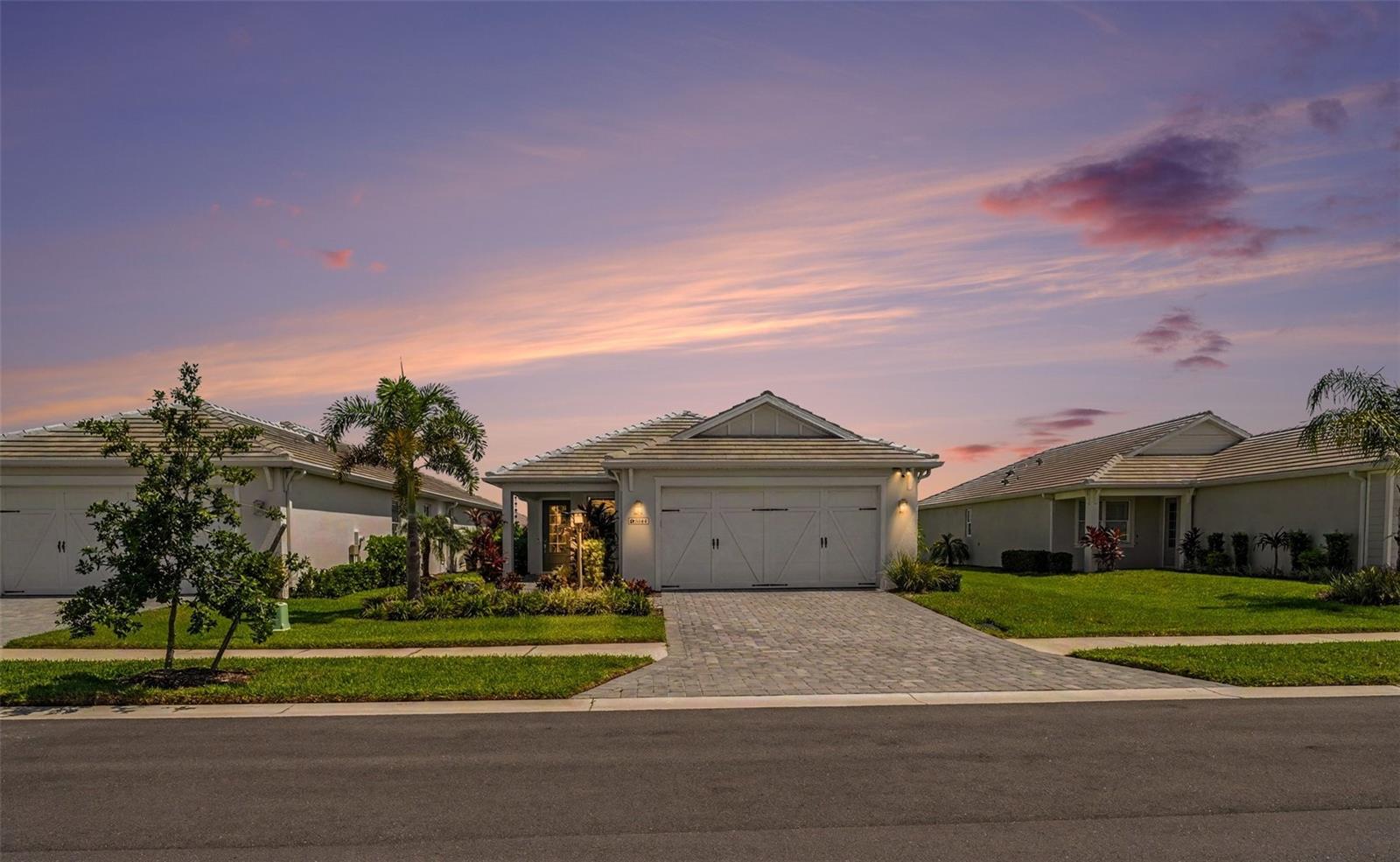 Why wait to build when you can move into this beautifully upgraded, better-than-new 2024 home in the highly sought-after LakeHouse Cove at Waterside? Thoughtfully enhanced well beyond builder grade, this meticulously maintained 3-bedroom, 2-bath residence offers the perfect blend of luxury, comfort, modern technology, and the vibrant Sarasota lifestyle.

Designed for effortless Florida living, the bright open-concept floor plan features soaring ceilings, abundant natural light, and a chef-inspired kitchen with quartz countertops, stainless steel appliances, a gas range, generous cabinetry, and a large center island overlooking the spacious living and dining areas. The extended 12-foot covered lanai with a panoramic screen enclosure creates an exceptional outdoor living space with peaceful water views and seamless indoor-outdoor entertaining. A natural gas connection is already in place, making it easy to add the outdoor kitchen or grill you’ve always wanted.

Thoughtful upgrades continue throughout the home, including smart ceiling fans in every room and on the lanai, TV-height electrical outlets with Cat6 wiring at every television location for a clean, modern entertainment setup, remote-controlled roller blinds in every bedroom, a dedicated 240V/60-amp garage connection ready for electric vehicle charging, a driveway security camera, and a video doorbell camera for added convenience and peace of mind.

The private owner’s suite offers a spacious walk-in closet, dual vanities, and a beautifully appointed walk-in shower, while two additional bedrooms provide flexibility for guests, a home office, or hobbies.

Life at LakeHouse Cove at Waterside extends far beyond your front door. Residents enjoy a spectacular lakefront clubhouse, resort-style pool and spa, state-of-the-art fitness center, pickleball and bocce courts, kayak launch and storage, scenic walking and biking trails, dog parks, and an active social calendar.

Even better, you're just a short walk or golf cart ride to Waterside Place, where waterfront dining, boutique shopping, live music, a weekly farmers market, and year-round events create one of Sarasota's most desirable lifestyle destinations. Downtown Sarasota, UTC, SRQ Airport, and the area's award-winning Gulf beaches are all just a short drive away.

Luxury, location, lifestyle—and all the premium upgrades are already done. This is a rare opportunity to own a truly move-in-ready home in one of Waterside's most desirable communities.