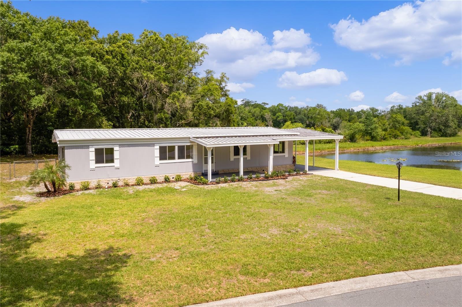 Pond front Home: Move-In Ready. Discover this 3-bedroom, 2-bathroom home situated on a serene 1/3-acre waterfront lot. Perfect for fun fishing, you can enjoy fishing right from your side yard and unwind in the evenings in your freshly renovated home. Located conveniently close to essential amenities without the burden of high HOA or amenity fees. Interior Features: Newly Painted: Both the interior and exterior have been recently painted. Laminate Flooring: Durable laminate flooring throughout creates a warm and welcoming atmosphere. Exterior Features: Private Fenced Backyard: Ideal for visiting grandchildren, pets, or entertaining guests. Carport: Spacious enough to accommodate two vehicles. Screened Lanai: Enjoy the outdoors year-round with a 20x10 ft covered and screened lanai, complete with an attached utility room and a removable handicap ramp. Community and Additional Benefits: Flexible HOA: Allows for an attached storage building and parking for boats or RVs in the rear of the home. Privacy: The irregularly shaped lot offers unparalleled privacy at the front, back, and sides of the property. Year-Round Sunshine: Enjoy Florida’s great weather without the hassle of snow. This home is competitively priced to sell and represents the best value in the neighborhood. Don’t miss out on this incredible opportunity! Contact us today to schedule a viewing and make this waterfront dream home yours.