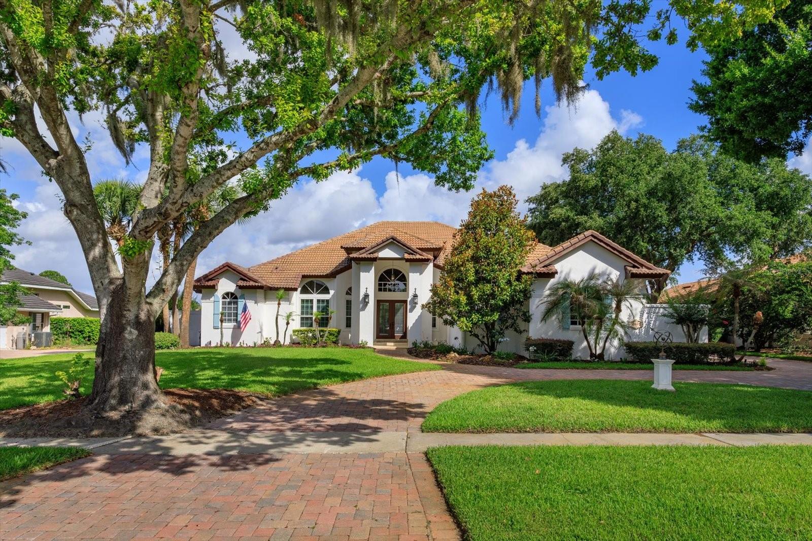 This stunning updated 4 bedroom/4 bathroom executive pool home in exclusive Windermere Club has been meticulously maintained and is the perfect place to call home!!! Upon entering the gated community you will be impressed by the oversized lots and sprawling custom homes. When arriving to the residence and turning into the circular paver driveway you will enjoy the homes classic elevation with a tall center gable and a neutral exterior palette with classic French blue shutters. Upon stepping through the double entry doors you will immediately sense this home is special with a fabulous floorpan, open and spacious, perfect for entertaining. Soaring vaulted ceilings, wood moldings, wood flooring, French doors and neutral interior tones all contribute to the allure of a classic and timeless residence. The home offers a study with double doors located off the entry Foyer with custom built-in cabinetry/shelves. The oversized Dining Room overlooks the beautiful swimming pool and patio and is open to the kitchen. The Gourmet Kitchen with 42" cabinets, gorgeous granite counters tops, beautiful glass tile backsplash, a center island, stainless steel appliances is open to the large Breakfast Nook and spacious Family room featuring a gas fireplace with a custom wood mantel making it the perfect space for winding down after a long day or enjoying family gatherings and holidays. The home also benefits from tremendous natural light through its many windows. The oversized Primary Bedroom is fit for a King and Queen with French Doors overlooking the pool, a spa-like 5-piece Travertine bathroom featuring a shower, soaking tub, double vanities and two large walk-in closets with custom built-in shelving systems. The 3 additional bedrooms include 2 with ensuite bathrooms and a 3rd that is served by a hall bathroom. All of the bathrooms have been updated with high-end finishes. The 3 car side-entry garage with spacious car park area offers convenience and significant storage. The Pool area with covered space, an outdoor kitchen/grilling station and nature views is perfect for Florida entertaining! Schedule a showing today and see this amazing home before it's gone!