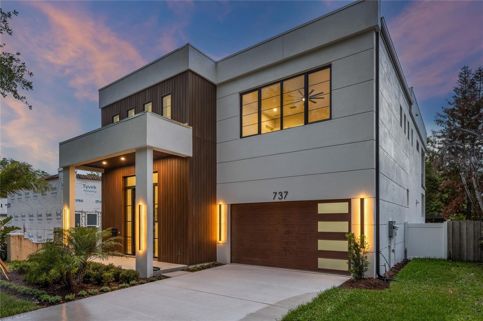 Crafted by Insight Construction, this extraordinary modern residence showcases an uncompromising level of craftsmanship, design, and construction quality that sets it apart from anything else on the market. Featuring solid concrete block construction on both levels and a striking architectural façade rarely seen in the area, the home immediately captivates with its bold presence, clean lines, and sophisticated modern aesthetic. Inside, a breathtaking two-story entry unfolds beneath soaring 24-foot ceilings, where a dramatic designer chandelier serves as a stunning focal point above sleek designer tile flooring that flows throughout the main living spaces. Natural light pours through expansive walls of glass, creating an atmosphere that feels both grand and inviting. The expansive living room was thoughtfully designed for elevated entertaining and seamless everyday living, anchored by oversized sliders that completely blur the line between indoors and out, transforming the space into a true indoor-outdoor retreat. At the heart of the home is a showpiece chef’s kitchen designed to impress at every level. Outfitted with premium stainless-steel appliances, a built-in refrigerator, custom cabinetry by Shapes Cabinets with integrated LED underlighting, and an oversized statement island, the kitchen combines functionality with exceptional design. An enormous walk-in pantry with extensive storage and a dedicated wine refrigerator further elevates the space, creating the ultimate culinary environment for both entertaining and daily living. The primary suite is a luxurious private sanctuary offering expansive proportions, a massive walk-in closet, and a spa-inspired bath designed with a refined modern aesthetic. The stunning wet room features a freestanding soaking tub, oversized walk-in shower, and dual vanities wrapped in designer finishes, creating a true resort-caliber experience. Every secondary bedroom features its own ensuite bath, offering privacy and comfort throughout the home, while an oversized upper-level balcony overlooks the backyard retreat below. Designed for year-round entertaining, the outdoor spaces are equally impressive, highlighted by a massive, covered lanai, resort-style pool, and expansive backyard rarely found in such a prime location. Perfectly positioned just moments from the vibrant dining and shopping of Mills 50, Downtown Orlando, and Lake Highland Preparatory School, this residence delivers an exceptional combination location and craftsmanship.