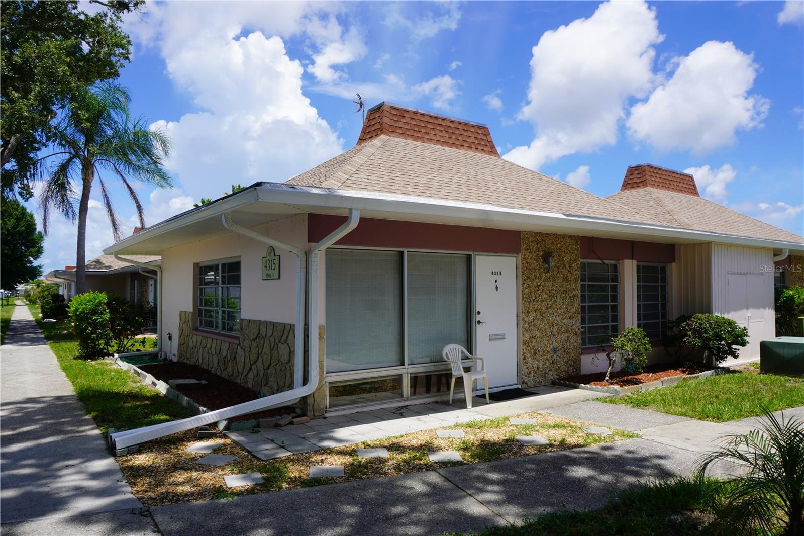 Welcome to easy Florida living in this charming 2-bedroom, 1-bath condo in the gated 55+ community of Tahitian Gardens. This private end-corner unit features a bright living area with wood laminate flooring, an inviting kitchen with ample storage and breakfast bar, comfortable bedrooms, and a laundry area with stackable washer and dryer that can be converted back to a half bath. Enjoy low HOA fees, maintenance-free living, and community amenities including a heated pool, clubhouse, and shuffleboard courts—Tahitian Gardens is a well-maintained gated community offering various activities, such as arts and crafts, a bicycling club, bingo, dominoes, card groups, and more. There is easy access to shopping and public transportation. CVS, Walgreens, Publix and Aldi are very close by with Tampa and Clearwater airports less than an hour away by car.  The property is also minutes from Tarpon Springs, the Sponge Docks, and Howard Park beach. Easy to see, shown by appointment only.