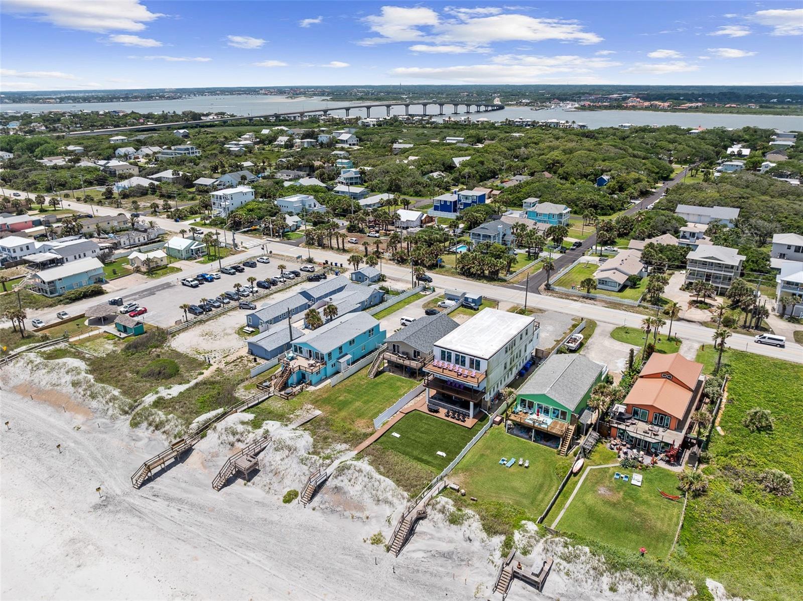 For more than 35 years, this oceanfront property has been the backdrop for generations of family memories, with the beach serving as an extension of the backyard. Now, the time is ripe for a new owner with their own vision to create a own coastal haven, whether as a private family retreat, an income-producing investment or a combination of both. Located at 3096 Coastal Highway, this legally zoned duplex is centrally positioned on a deep 275-foot lot, leaving ample space for the addition of a pool, expansive decking and outdoor entertaining areas to be enjoyed nearly all year-round. The upper-level residence serves as the primary living space and is accessed through a large foyer. A generous kitchen overlooks the dining and living areas, all oriented toward inviting vistas of the Atlantic Ocean. Large windows fill the home with natural light, and nearly every room enjoys a water view. The living room and primary bedroom open through sliding glass doors to an expansive deck spanning the width of the home. No better place to greet the sun and ocean breeze with morning coffee in hand. From here, a private boardwalk leads across the lawn directly to the sand and surf. The guest bedroom and bath are situated off the dining area, providing privacy and separation from the primary suite. Additional conveniences include a dedicated laundry closet and a small front porch where two can watch the brilliant sunset skies. The first-floor apartment features a private entrance on the north side of the home. Its open-concept kitchen, dining, and living area extends to a covered patio through sliding glass doors. Two bedrooms share a full bath, and the unit includes its own laundry room, making it well-suited for guests, extended family, or rental income. For buyers seeking a single-family configuration, the home's layout naturally lends itself to multi-generational living, with distinct spaces that offer both
togetherness and privacy. A single-car garage provides valuable storage or sheltered parking for your beach vehicle and recreational gear. Just ten blocks from the heart of Vilano Beach, residents enjoy convenient access to the area's vibrant commercial district, featuring restaurants, shops, live music venues, hotels and a major grocery store. A short drive across the bridge leads to the historic charm of St. Augustine, where renowned dining, shopping, cultural attractions and exploration of historic sites await. Whatever your intended use or uses might be, this oceanfront duplex offers versatile options to explore. Just don't forget your straw hat!