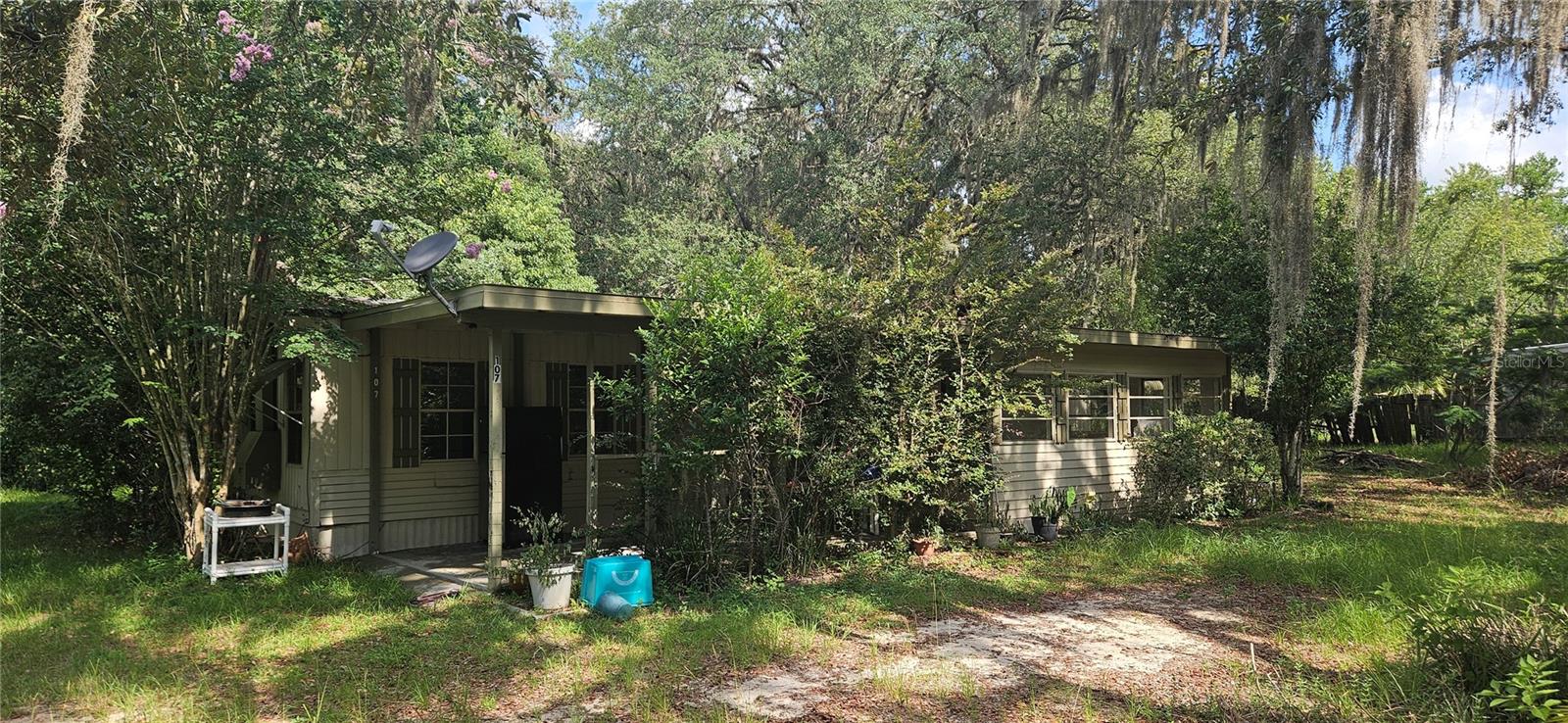 Quiet Homestead or PORTFOLIO ADDITION OPPORTUNITY!
Set on more than a half-acre beneath mature live oaks, magnolias, and native landscaping, this 3-bedroom, 2-bath home offers a private setting with room to spread out. The spacious open living area flows into the kitchen, while the additional enclosed front room provides flexible space for a home office, hobby room, or second living area.
Recent updates include the HVAC and septic system, allowing attention to be focused elsewhere. Outside, the carport and detached outbuilding with a concrete floor add practical storage and workspace options.
Whether you're expanding a rental portfolio or looking for your next investment, this property offers a combination of usable space, a generously sized wooded lot, and improvements already in place that make it worth a closer look.