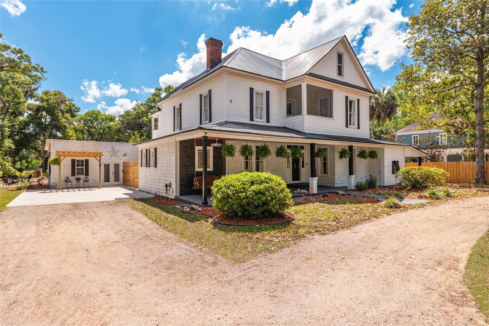 AN EXPANSIVE PRIVATE ESTATE SANCTUARY NEAR OCALA & GAINESVILLE. Experience ultimate privacy and turn-key sophistication on 10 serene acres in Williston, combining the timeless architectural elegance of a beautifully preserved 1901 three-story estate with state-of-the-art modern infrastructure.
Sprawling over 5,511 sq. ft., this historic masterpiece features 5 spacious bedrooms and 4 baths, meticulously updated for today's luxury lifestyle without sacrificing its original character. The estate is a fully connected Plug-and-Play Remote Work Sanctuary, equipped with premium Starlink satellite internet and a multi-zone mesh network delivering blazing-fast Wi-Fi throughout the home, paired with smartphone-integrated smart home security systems.

Designed for world-class hosting and multi-generational living, the home features a massive 1,500 sq. ft. entertainment room that flows seamlessly out to a spectacular, fully screened 33,000-gallon pool oasis. Need an absolute quiet zone? The estate boasts a dedicated private office wing, creating the perfect professional work environment completely removed from the main living areas.

From the intricate architectural details, hand-painted wallpapers, and gleaming hardwood floors to the durable black metal roof (complete with a transferable warranty), every inch of this property exudes luxury. Enjoy the incredible benefits of low Levy County taxes while maintaining unparalleled access to the region's best infrastructure—located just minutes from Ocala's world-famous equestrian venues (WEC), less than 35 minutes to regional airports, and a direct, easy commute to Gainesville's premier UF Health Shands medical facilities. Schedule your private tour today to experience this unparalleled lifestyle compound.