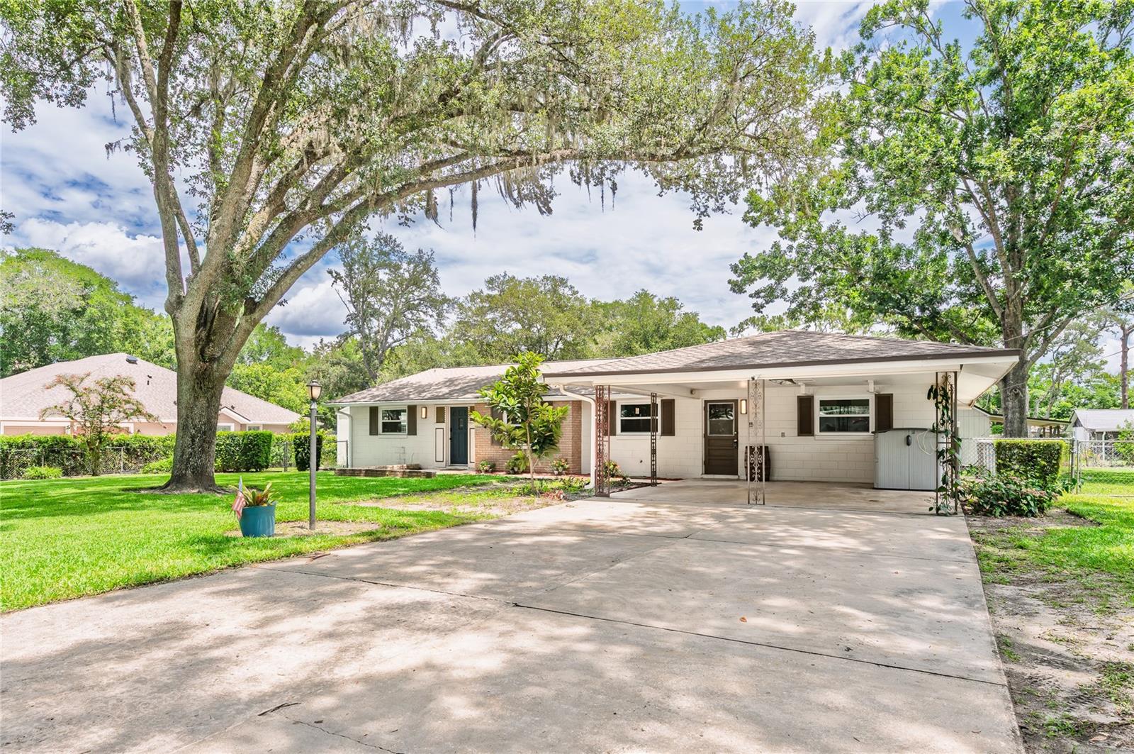 Welcome home. Nestled in the heart of Sanlando Springs, This updated and upgraded mid-century home embodies a slice of classic Florida living with the modern conveniences of nearby shopping, restaurants and more. This timeless 3 bedroom, 2 bathroom home sits on an ample .40 acre lot with a barn and a shed with mini-split HVAC to boot. Upon arrival you will be greeted by the over-size driveway and large front yard with mature trees. A front yard big enough to play catch and even entertain family and guest. The 2 car carport is convenient and if you have the vision can be converted to a 2 car garage. The interior floorplan is highlighted by an effortless open floor plan perfect for entertaining, split bedroom design, a redesigned/ upgraded kitchen with breakfast island bar top, and dry bar, a Florida room, covered and screened in rear patio and oversized utility/laundry room. The outdoor space wraps all the way around the home includes a large barn/workshop with a covered patio. A second insulated shed (2025) with a mini split installed and wall paneling is also included in the sale. Additional outdoor highlights include a outdoor shower and a wooden playground playset. The right side gate is large enough to pull a large trailer, additional vehicles, boats etc. Multiple updates and upgrades have been made by the seller include but are not limited to: Newer HVAC with UV light sanitation, airducts, cleaned and sanitized 2024, Stainless steel like kitchen appliances 2024, water heater 2024, complete kitchen remodel 2024, LVP flooring 2024, New Windows 2024, Roof was soft washed 2024, sprinkler system pulls from the well and not the city, septic pumped and inspected 2024, newer drain field, plumbing piped 2020, 100 amp electrical panel in shed, new 150 amp outdoor panel, whole home surge protection with lifetime warranty, GFCI's installed in wet areas, hardwired carbon monoxide/ smoke detectors installed throughout the home, and installed new tamper resistant receptacle's. Don't wait and miss this beautiful updated home. They don't come across too often. Make it yours today.