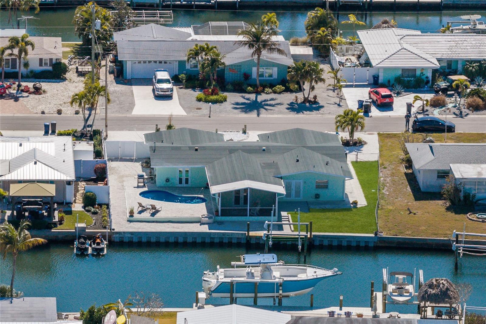 Only 5 photos (living room dining room area) have been virtually staged.  WELCOME to a boaters dream, do not miss out on this fabulous waterfront home.  This is luxury waterfront living, just minutes by land or water to the sugar-sand beach's and local coastal dining on Anna Maria Island.  Flamingo Cay is a very convenient and lovely waterfront neighborhood positioned right between the island and the mainland, allowing for great access to all that west Bradenton also has to offer including dining , shopping , parks and recreation, golf courses, movie theater's, museums, and much more.  This exceptional 3 bedroom 3 bath pool home offers you a completely updated new kitchen, featuring new cabinets, new fixtures, new quartz counter tops, all new appliances, and new flooring.  It is hard not to notice the wonderful open floor plan, where the kitchen is in the middle and is perfect for entertaining featuring one large island and a breakfast bar great for food and beverage set up .  In addition to the new interior spaces,  there is a new roof, new AC , hot water tank, pool pump, and all new fresh paint inside and outside.  The primary bedroom also has a large bonus room.  This space is large enough for an office, nursery or media room, currently being used as a second extra large walk in closet.  It is also large enough to add an island in the middle for more storage, or clothing and a folding area.  The home also has a second en-suite bedroom bath convenient with its own exit to the pool and backyard patio perfect for when you have overnight guests. Plenty of parking out front with the circular drive and the 2-car garage provides plenty of space and storage.  The backyard offers over 90 feet of water frontage with a brand new seawall and direct access to the inter-coastal where you can experience beautiful sunsets or dining at one of the many waterfront restaurants in just minutes. As far as this lovely home goes, there really is absolutely nothing to do but to bring your boat and start living your best Florida life.  Do not let this one slip away or miss out on your opportunity to live on the water.