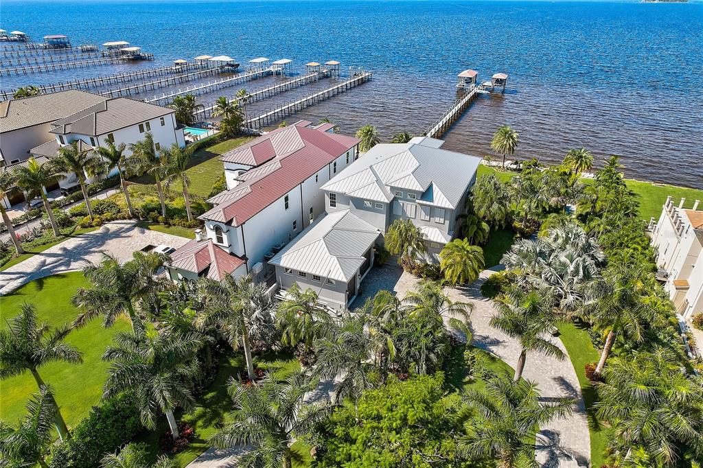 The “Surfside-Waterfront- Estate” at Apollo Beach, offers 120ft of Tampa Bay waterfront with amazing sunsets and endless panoramic views of Tampa Bay, Downtown Tampa/Downtown St Petersburg’s Skyline as well as the Landmarked “Skyway Bridge”. The home boasts, some the most luxurious amenities, design and luxury living to include; Private Doubled Gated Access, 3-Stop Elevator, Generac Home Generator, Completely Fenced, Pavered Circular Driveway/Walkways throughout the grounds, a 300ft Composite Dock w/Covered Boat Lift(18K), a Jet Ski Lift and 2 Paddle Board Lifts.
Elegant double front doors allow entry into this 5-Bedroom, 4-Bathroom & 1½ Bath Home. Your greeted with breath taking views and natural lighting. The 1st floor Owners Retreat is an elegant space with a bayfront sitting area and lanai, take the elevator to the 2nd floor to find additional 4 Bedrooms/ 3 Baths, living area, wet bar w/refrigerator and lanai.
Luxury appliances include: 5 Burner "induction" Mercury Professional Range, GE Café series 30” french door wall oven w/ warmer drawer, Monogram Drawer Microwave, Thermador Topaz silent dishwasher, Kruas Undermount Sink, April Aire Filtration/Dehumidifiers and more. The Flooring/ Back Splash/Counter spaces and Bath Walls includes; Porcelain, Marble, Quartzite, Luxury Tile, and Glass Tile. Custom High End Soft Close, Under-lighting Cabinetry and hardware throughout includes; Robern Mirrors (medicine cabinets) and Mid Continent. The Elan, Smart Home A/V system allows simplistic control of audio/video/surveillance devices and be entertained by the Sonos Surround System throughout the Home, Garage and Lanai’s.
Enjoy Luxurious Outdoor living with the Infinity Edge Saltwater Pool surrounded by Travertine Tile, Screened Lanai, Outdoor Kitchen w/ LYNX 42” Stain Steel Grill w/ Side burner, hood and blower. The grounds have "Lush Tropical Landscaping" with “Mosquito Misting System” allowing the most pleasant level of Florida Outdoor Lifestyle/Living. The enormous 3 Car oversized garage, with custom hurricane rated garage doors and a large w/ac workspace. 
This is truly a ONE-OF -A KIND Home, located in one of the most sought-after areas in Apollo Beach and is one of the most unique properties in the Tampa Bay area. To many aspects and features to describe. This home is IMPRESSIVE and a MUST SEE! This is the “GEM” Call Today!