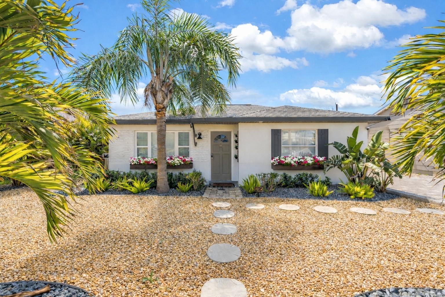 Virtually Staged. Welcome to your coastal retreat. This beautifully renovated block construction home blends modern updates with timeless beachside charm, offering the perfect opportunity to enjoy the relaxed Florida lifestyle.

This thoughtfully designed 2-bedroom, 1-bath residence features an open floor plan with stylish tile flooring throughout, creating a bright and welcoming living space. The updated kitchen is a standout, complete with stone countertops, custom wood cabinetry, and brand-new stainless steel appliances—perfect for both everyday living and entertaining.

The bathroom has been tastefully updated with a double vanity and elegant tilework, combining functionality with a clean, modern aesthetic. Both bedrooms are generously sized with ample closet space, while all-new window treatments add a polished finish and privacy throughout the home.

Just off the kitchen, a charming sunroom offers the ideal spot for morning coffee or evening wine. Outside, the beautifully landscaped, low-maintenance yard creates a private outdoor setting perfect for relaxing, grilling, and enjoying the coastal breeze.

A unique feature of the property is the detached 240 sq. ft. block construction garage, offering incredible versatility—it could easily be converted into a studio, office, workshop, or additional living space.

Recent upgrades include a whole-house water purification system, new hot water heater, new irrigation system, new interior washer and dryer, and an updated HVAC condenser, providing peace of mind for the next owner.

Ideally located just minutes from Caddy’s, The Candy Kitchen, The Reef Bar & Grill, John’s Pass, and the beautiful Gulf beaches, this home places dining, shopping, entertainment, and the sand at your fingertips.