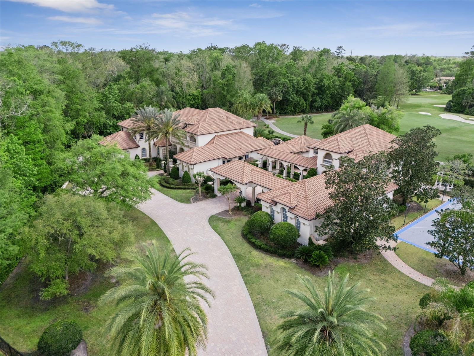 Behind three private gates, this extraordinary home offers a rare opportunity to own one of Central Florida’s most impressive luxury residences located in the gated Enclave within the guard-gated community of Alaqua Lakes! This compound is sited on 1.55 acres overlooking the 8th hole of the Legacy Club golf course and no neighbors on three sides is truly a buyer’s dream come true. The property includes a 3114 sq ft separate guest house complete with a kitchen and living space on the main level and a bedroom, bonus room/game room & massage room upstairs making it perfect for multigenerational families or hosting visitors.

The main residence boasts elegant living featuring soaring ceilings, refined architectural details and thoughtfully designed living spaces.
The first floor highlights an unrivaled owner’s retreat privately situated and complete with a marble-surround gas fireplace, sitting area, spa-like bathroom and expansive walk-in closets. A secondary en suite bedroom, formal living and dining spaces and an elevated office complete the main level of this home. The updated gourmet kitchen is a true showpiece featuring stainless steel appliances, custom cabinetry, a stunning marble island and a large walk-in pantry all opening seamlessly to the family room. Unique features such as a saltwater aquarium and a private side porch with remote-operated screens overlooking the koi pond and putting green add to the home’s distinctive charm.
Upstairs you’ll find 4 bedrooms and two expansive entertaining areas. The game room and bar make entertaining effortless as this entire level feels like its own private lounge with a beautiful bar and custom cabinetry through out. The adjacent second entertaining area is a fully loaded home theater complete with a bar to take movie nights to a new level designed for an immersive experience right at home. 

The outdoor living experience is nothing short of spectacular! Designed as a private resort, the grounds feature an extensive covered lanai, a summer kitchen, an outdoor cabana bar, adjacent pool bath & outdoor shower and a tropical heated pool and spa with a grotto with built-in bench seating and fountains all overlooking the sweeping golf course views. Enjoy tranquil moments by the koi pond, practice on the private putting green or entertain effortlessly in this one-of-a-kind setting. A basketball/sport court and whole home generator adds to the estate’s exceptional lifestyle offerings.


A 6-car garage, 4 in the main residence and 2 in the guest house plus an add'l golf cart bay, and fully fenced property completes this remarkable property.
With its prime golf course setting, extensive upgrades and unparalleled amenities, this estate represents the pinnacle of luxury living in one of Central Florida’s most sought after communities. Alaqua Lakes is set within a premier golf course community where residents enjoy world-class amenities including clay tennis courts, a resort-style pool, playground and sports field, a 24-hour guard-gated entrance and enhanced community security. Located near A-rated schools, Central Florida’s best attractions, upscale shopping and dining, major highways and international airports.