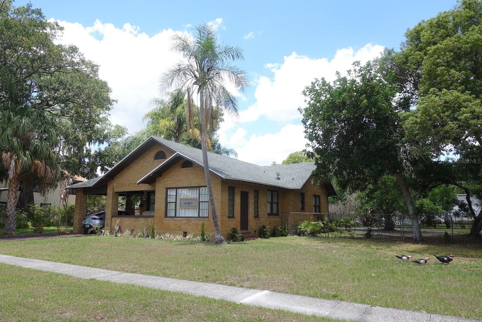 Historic Lakeland Florida Home—between Tampa and Orlando— this 2241 SF 3/2/2  bright 1925 vintage home preserves its original character while offering the comfort and functionality of modern living. Enjoy the large covered, front porch. Preserved original wood floors, dedicated living room with working fireplace, and office/sun-room with terracotta tile and separate entrance. Featuring a formal dining room containing a separate entrance. The spacious pantry, state-of-the-art kitchen with stainless steel appliances, new quartz countertops and sink create ease & ambiance. The indoor separate laundry room has generous storage. There is a charming guest suite with private bath and separate entrance. A oversized, 2 car freestanding garage offers potential for guest quarters, rental income or multi-generational living. Large fenced private yard featuring mature shade providing trees, and kennel space for pets. Recent improvements include a new roof, energy-efficient tank-less water heater, updated electrical and plumbing, with central air & heating. Walk or bike to bustling downtown Lakeland’s farmers market, shopping, scenic lakes, restaurants, theaters, and medical centers. This home offers an exceptional combination of historic charm, location, and lifestyle.  A major advantage of Shore Acres is its prime location near downtown Lakeland's amenities—without the requirements of a designated historic district. Buy with confidence! A new home warranty is included with the sale, offering valuable protection with added peace of mind for your first year of ownership.
