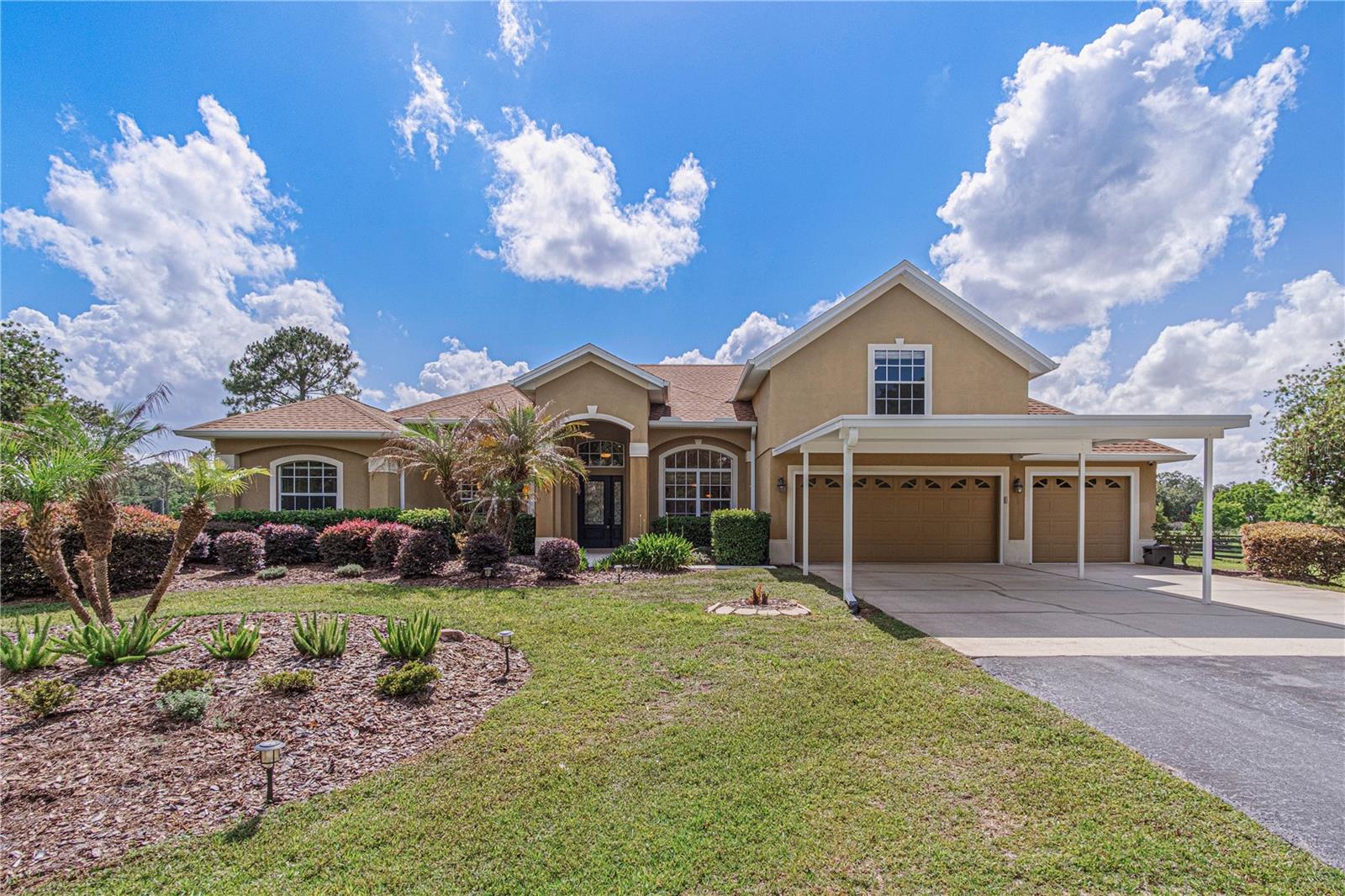 One or more photo(s) has been virtually staged. Welcome to your own private country retreat, where luxury living meets wide open space. Enter through a private gated entrance and travel down the long driveway to this impressive estate situated on 10 fully fenced acres, offering both privacy and endless possibilities. This spacious residence offers approximately 2,800 square feet of thoughtfully designed living space featuring 4 bedrooms, 3.5 bathrooms, and an upstairs flex space perfect for a home office, media room, gym, or playroom. The primary suite is conveniently located on the first floor, creating a peaceful owner's retreat with comfort and privacy in mind. Designed for both everyday living and entertaining, the home blends functionality with modern upgrades including hurricane impact windows and a dual-zone air conditioning system for enhanced comfort and efficiency. Step outside to your own backyard oasis featuring a heated saltwater pool surrounded by a screened enclosure, allowing you to enjoy Florida living year-round in comfort and style. The expansive acreage provides room for horses, recreational vehicles, agricultural use, or simply enjoying the tranquility of country living. Adding even more value, the property currently benefits from an agricultural tax exemption already in place. This exceptional estate offers the rare combination of acreage, privacy, modern conveniences, and resort-style amenities all while providing the peaceful lifestyle you've been searching for. Age of Roof, 3 years, A/C, 1 year and Water Heater, 3 Years.