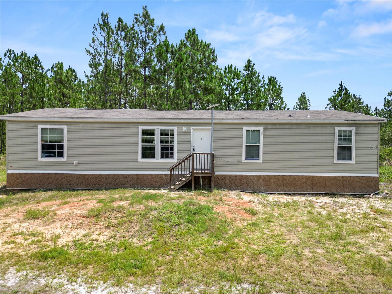 Escape to the peace and privacy of country living with this unique 18.75-acre family compound, offering the perfect blend of modern comfort and endless outdoor recreation. Built in 2023, the nearly new 1,680 sq. ft. manufactured home features 3 bedrooms, 2 bathrooms, an inviting open-concept kitchen, and a desirable split floor plan designed for comfortable everyday living. The spacious family room showcases built-in shelving with integrated wall storage, adding both style and functionality. The home is serviced by a private well and septic system, both installed new with the home's construction, while underground electric service enhances the property's clean appearance and reliability.

Embrace the country lifestyle surrounded by Florida's natural beauty and abundant wildlife. Enjoy the privacy and space to explore your own land, observe native wildlife, forage for native plants (where appropriate), or create your own outdoor adventures. With nearly 19 acres, there's ample room to enjoy ATVs, UTVs, dirt bikes, or other off-road recreational vehicles on your own property, making this an ideal retreat for outdoor enthusiasts.

The sale includes two parcels totaling approximately 18.75 acres, creating exceptional flexibility for future expansion, a private retreat, or investment potential. Parcel 13-24-24-0001-000-19700 consists of approximately 10.72 acres, including a 1-acre homesite with the residence and approximately 9.72 acres of wetlands. Parcel 13-24-24-0001-000-31700 offers approximately 8.03 acres, including a 1-acre vacant residential homesite and approximately 7.03 acres of wetlands. Whether you're looking for a secluded homestead, a recreational getaway, or a peaceful place to enjoy nature, this one-of-a-kind property delivers privacy, modern conveniences, and room to live the Florida outdoor lifestyle you've been dreaming of.