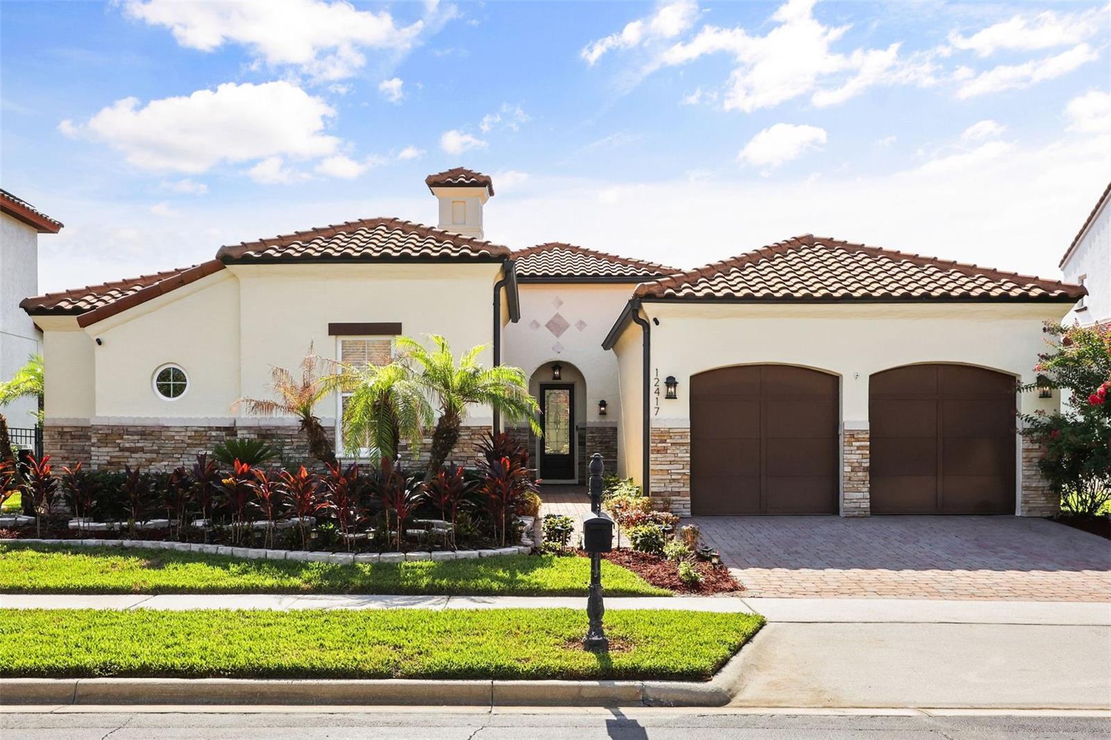 Welcome to this impeccably designed, all-on-one-floor luxury custom home located in one of the most sought-after gated communities of Windermere, Casa Del Lago, where timeless Mediterranean architecture meets refined Florida living.
This exceptional home offers four bedrooms and four full bathrooms and is thoughtfully designed with custom details, designer features, modern décor, graceful indoor-outdoor flow, and resort-style outdoor living.
From the moment you arrive, the home makes a lasting impression with its classic barrel tile roof, stone-accented exterior, brick-paved driveway, lush landscaping, and charming private courtyard entry.
Inside, you are greeted with style and elegance, welcomed by soaring ceilings, elegant archways, rich crown molding, designer lighting, beautiful travertine flooring throughout the main living areas, and hardwood flooring in the bedrooms.
The bright and inviting formal living and piano room features tray ceiling details and expansive sliding glass doors that open to the covered lanai and pool area, creating a seamless connection between indoor comfort and outdoor relaxation.
The open layout flows beautifully into the family room, making it ideal for everyday living and entertaining. The family room showcases a beautiful onyx wall with an electric fireplace and built-in surround sound system, creating a warm and elegant focal point for the home.
The gourmet kitchen offers granite countertops, custom cabinetry, premium appliances, a built-in oven, microwave, refrigerator, dishwasher, disposal, gas cooking, kitchen exhaust hood, and a water filtration system. It connects to the butler’s area, which leads to the formal dining room.
The private owner’s suite is thoughtfully separated from the secondary bedrooms, offering a sense of personal sanctuary and a peaceful retreat with generous space and a luxurious bathroom featuring dual vanities, a garden tub, and a frameless glass shower. Additional bedrooms provide comfort and flexibility for family, guests, or a home office. The home also features custom built-in closet shelving, providing excellent storage and organization.
The outdoor living area is truly special, featuring a screened covered lanai with rich wood ceiling detail, built-in surround sound system, gas grill, outdoor vent hood, dining area, and lounge space overlooking the sparkling heated pool and jacuzzi/spa. Surrounded by tropical landscaping, palm trees, privacy walls, fencing, water features, and multiple seating areas, the backyard creates a private resort-style setting perfect for relaxing, entertaining, and enjoying beautiful Florida evenings — with the added charm of being close enough to enjoy Disney-area fireworks.
Additional upgrades include a Tesla charger connection and thoughtful custom features throughout the home. This home offers convenient access to Disney theme parks, world-class entertainment, shopping, restaurants, major highways, and some of the area’s top public and private schools, including nearby Windermere Preparatory School.
A rare opportunity to own a custom luxury home with timeless design, elegant finishes, privacy, and exceptional indoor-outdoor living in one of Central Florida’s most desirable locations. This home is truly a dream come true.