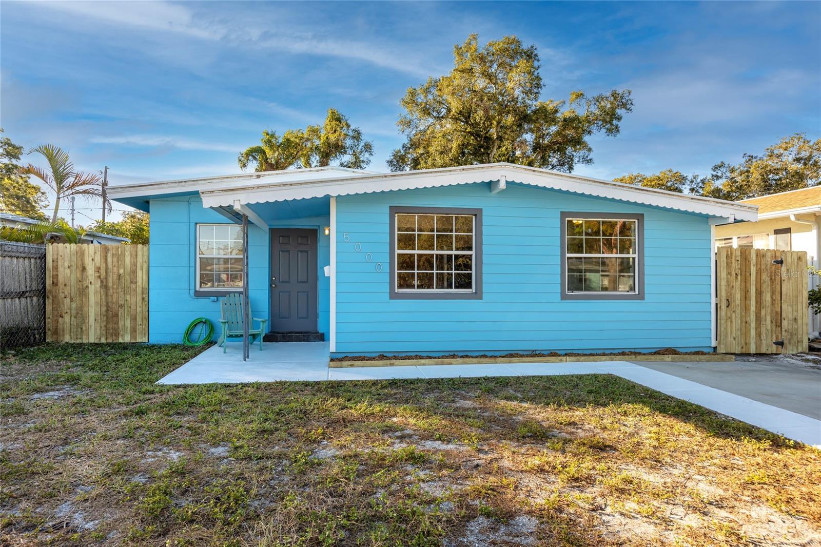 One or more photo(s) has been virtually staged. Centrally Located St. Pete Gem! This 3-Bedroom, 2-Bathroom Coastal Cottage/Cape Cod inspired Home features gorgeous and gleaming newly restored and polished Terrazzo Floors. The Terrazzo is neutral in color, has no grout and is easily maintained.  Other interior features include a lovely Dining Area with decorative coastal plank ceiling adjacent to the open Kitchen, a Split-Bedroom Plan, and Inside Laundry!  All three Bedrooms have nice-size closets that are either semi-walk in, or completely walk-in.  The Main Bathroom includes a tub/shower combo, and the Second Bathroom includes a walk-in shower.  The large, fenced-in Backyard is easily accessible and includes a large cement pad perfect for basketball, play or create a dining/grilling area for entertaining!  There is also a large 2-Story Barn-Style Shed complete with a Loft for lots of Storage! It even has Electricity Connected for your Workshop Needs!  Interior and Exterior were just painted in October 2023!  This home is Block Construction (under concrete siding), except for the addition (separate bedroom, second bathroom/laundry room and hallway on west side of house) which is wood frame and was completed in 2012 (permit on file). Roof replaced with TPO in 2013 (permit on file). A/C recently maintained in October 2023 and U/V air purification system was professionally installed.  This Home is located about a 17-minute drive to Downtown St. Pete, about 17-minute drive to St Pete Beach, about 8-minute drive to Interstate 275, and 2-minute drive (or 5-minute walk) to grocery shopping, retail stores and dining. Schedule your Showing before this Gem is gone!