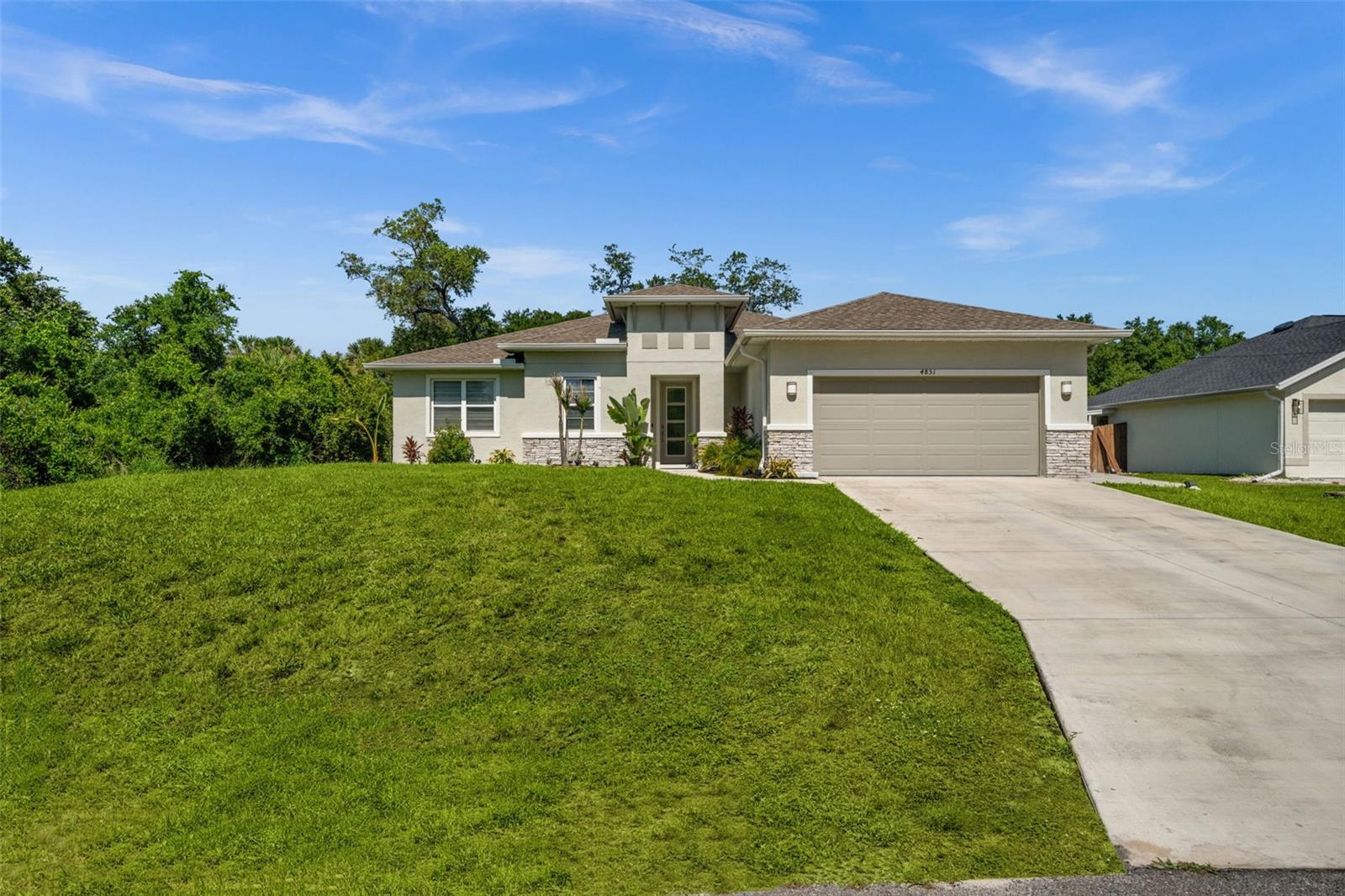 This well-designed 3-bedroom, 2-bath home offers 1,929 square feet of comfortable living space, plus a dedicated office and an oversized 2-car garage. Thoughtfully laid out and full of upgrades, it combines functionality with stylish details throughout. Inside you’ll immediately notice the custom woodwork that adds warmth and character to the main living areas. The living room also features a sleek built-in electric fireplace, creating a cozy focal point for relaxing or entertaining. Just off the entryway, a convenient front closet provides practical storage for guests, coats and everyday essentials. The kitchen is finished with stone countertops and offers ample workspace for cooking and hosting. All three bedrooms are generously sized—each large enough to accommodate a king-size bed—and feature custom closet systems that maximize organization and storage. The separate office/flex room provides the perfect space for working from home, hobbies or additional living needs. Step outside to enjoy a screened lanai and a very private backyard, ideal for quiet mornings, evening gatherings or simply unwinding in your own outdoor space. Hurricane shutters offer added peace of mind and the deep 2-car garage provides extra space for storage, tools or recreational equipment. Located in a peaceful area with no flood zone, no HOA and no CDD fees, this home also offers outstanding convenience. You’re just minutes from major shopping and dining options, including Home Depot, Publix, Ross, TJ Maxx, Burlington and more—making everyday errands quick and easy. Beaches, boating, fishing, golf and parks are all within a short drive, allowing you to fully enjoy the Florida lifestyle. With quality finishes, smart storage solutions, privacy and a prime location, this home truly checks all the boxes.