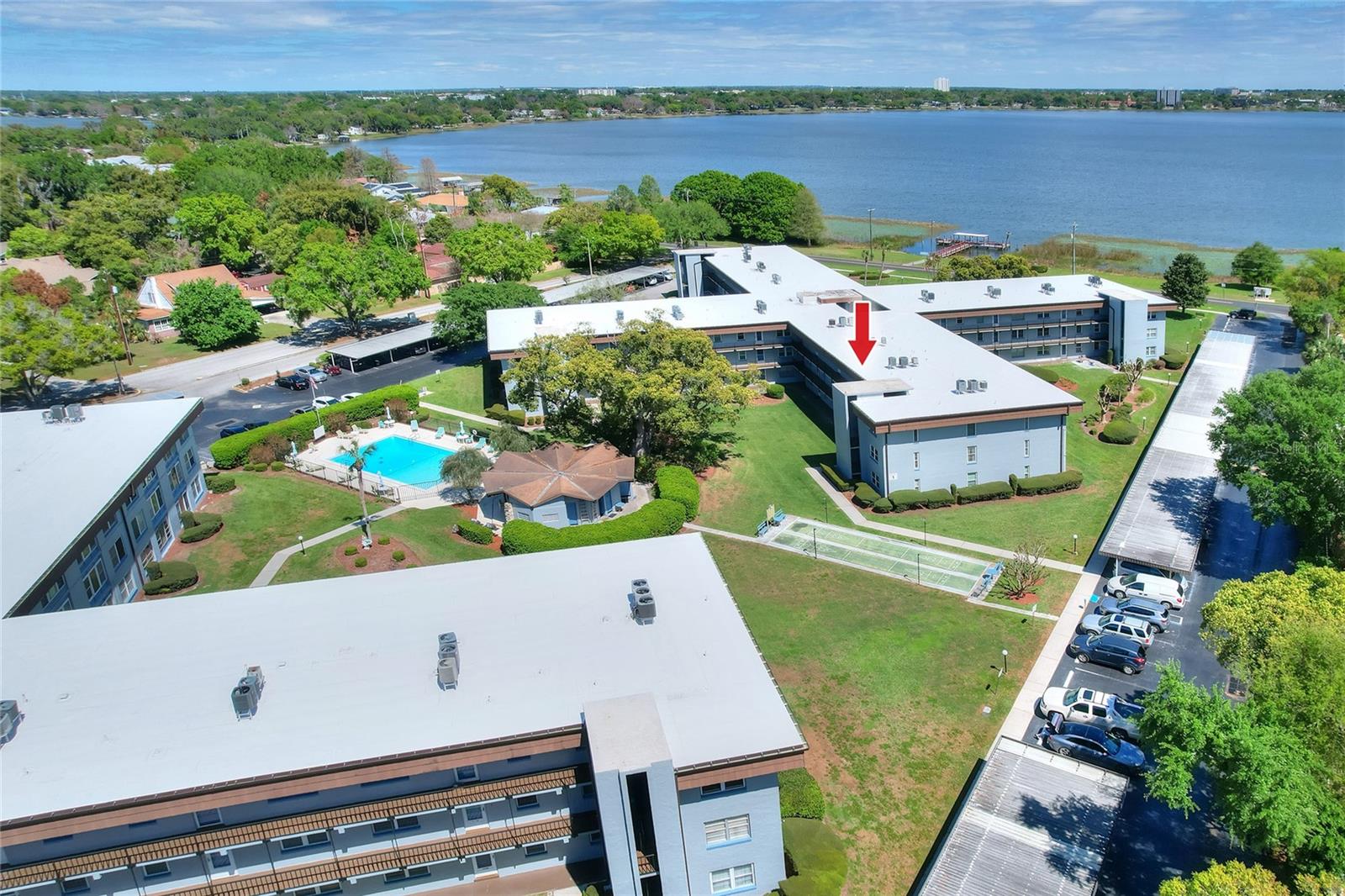 Enjoy a relaxed, maintenance-free lifestyle in this well-loved 55+ condo overlooking the beautifully maintained grounds of Imperial Harbours and the shores of Lake Howard. From both the bedroom and enclosed Florida room, take in peaceful views of the community pool and landscaped courtyard—an ideal backdrop for quiet mornings or unwinding at the end of the day.

Located in Building Two, this second-floor unit offers convenient access via elevator or stairs and provides a comfortable, easygoing layout designed for everyday living. The bright and open great room flows seamlessly into the dining area, creating a welcoming space for both relaxing and entertaining.

The primary suite is spacious and features a walk-in closet along with a private en suite bath complete with a step-in shower. The guest bedroom offers flexibility for visitors or additional use, while the kitchen provides ample cabinetry, stainless steel appliances, stone countertops with workspace for everyday needs.

Interior features include tile flooring throughout and the convenience of an in-unit stackable washer and dryer.

Residents enjoy a variety of amenities, including a lakeside fishing pier, community pool, fitness area, meeting room, assigned covered parking, and extra storage. The condo fee simplifies daily living by covering cable, internet, water, sewer, trash, exterior maintenance, and grounds care.

Ideally situated just minutes from shopping, dining, and the charm of downtown Winter Haven, this property offers an easy, enjoyable Florida lifestyle with lake access right at your doorstep.