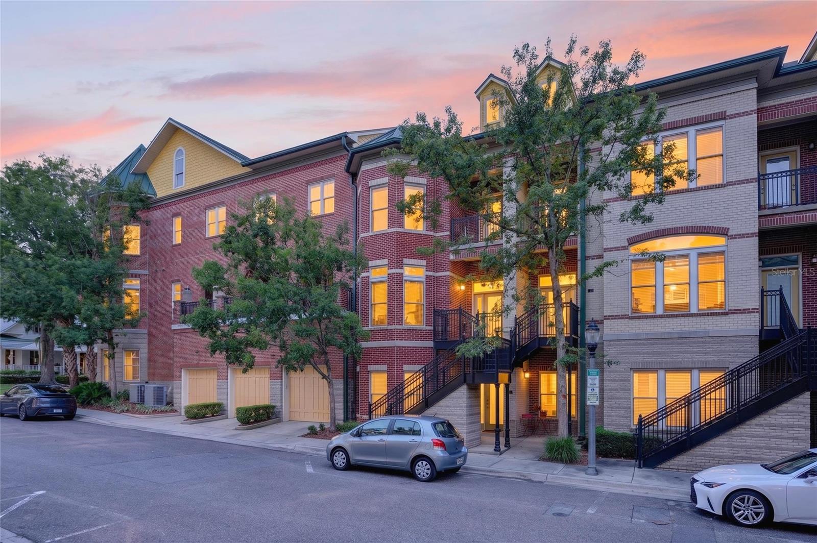 Experience the best of downtown Gainesville luxury living in this beautifully updated 2-bedroom, 2.5-bath townhome in the highly sought-after Regent's Park community, perfectly positioned on a quiet, tree-lined street at the edge of Gainesville's historic district. Offering the ideal blend of sophistication, walkability, and low-maintenance living, this residence is perfect as a full-time home, an upscale game-day retreat, or a second home for professionals affiliated with the University of Florida, UF Health Shands Hospital, or downtown Gainesville. Designed with the feel of a luxury single-family home, the open-concept floor plan features spacious rooms, soaring 10-foot ceilings, and beautiful wood flooring throughout the main living level, complemented by newly upgraded cork flooring on the staircase and throughout the upper level—eliminating carpet entirely. The stunning, fully renovated kitchen (2018) showcases quartz countertops, 42-inch wood cabinetry with designer hardware, stainless steel appliances, a dedicated beverage station with space for a wine refrigerator, and an oversized breakfast bar that flows effortlessly into the dining and living area, creating the perfect setting for entertaining. Large windows fitted with custom silhouette shades fill the home with soft natural light while maintaining privacy. Just beyond the living room, the expansive private terrace extends your living space outdoors with plenty of room for dining, grilling, gardening, sunning, or simply relaxing beneath the mature tree canopy. Upstairs, the elegant owner's suite offers a spacious walk-in closet, a luxurious ensuite bath, and a private balcony overlooking the picturesque tree-lined streets of Gainesville's historic district—the perfect place to enjoy your morning coffee or unwind in the evening. A generous 2nd bathroom with its own private bathroom provides comfort and privacy. Additional features include an in-unit laundry closet with washer and dryer, newly upgraded kitchen and bathroom faucets, an attached one-car garage tucked behind a gated entrance, and fiber-optic internet included in the monthly condominium association fee. Constructed using Insulated Concrete Forms (ICF) with a classic brick veneer exterior and Andersen windows, this home offers exceptional energy efficiency, superior sound insulation, increased storm resistance, and lower utility costs compared to traditional construction. One of Regent's Park's greatest advantages is its unbeatable location. Step outside and enjoy one of Gainesville's most walkable neighborhoods, with easy access to Depot Park, Sweetwater Preserve and Trails, the Hippodrome Theatre, the Thomas Center, the Alachua County Public Library, Bo Diddley Plaza, Heartwood Soundstage, First Magnitude Brewing Company, and many of downtown Gainesville's most popular restaurants, coffee shops, breweries, farmers markets, and year-round festivals. The University of Florida, UF Health Shands Hospital, Innovation District, and Ben Hill Griffin Stadium are all just minutes away, making this an exceptional choice for faculty, medical professionals, graduate students, alumni, and Gator fans alike. Whether you're searching for a luxury downtown Gainesville condo, a maintenance-free home near the University of Florida, or an elegant lock-and-leave residence in one of Gainesville's premier communities, this exceptional Regent's Park townhome offers a lifestyle that is truly second to none.