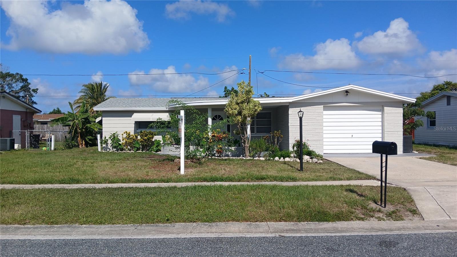 Welcome to this beautifully updated 2-bedroom, 2-bath home located in the desirable Holiday Gardens subdivision of Holiday, Florida. Thoughtfully renovated with quality finishes throughout, this move-in-ready home offers peace of mind with a new water heater (2020), brand-new roof (2025), new A/C system (2026), and fresh interior and exterior paint. Best of all, the property is not located in a flood zone, offering added value and potential savings on insurance. The stunning kitchen has been completely remodeled with custom shaker-style cabinetry featuring new plywood construction, dovetailed drawers, soft-close doors and drawers, elegant quartz countertops, and a full suite of stainless steel GE appliances. Throughout the home, you'll find high-quality commercial-grade luxury flooring with a durable 30-mil wear layer, providing both style and long-lasting performance. The spacious floor plan includes two comfortable bedrooms and two full bathrooms, with the second bathroom conveniently located inside the home—not in the garage. A bright Florida room provides additional living space and could easily be converted into a third bedroom, home office, hobby room, or flex space to fit your needs. Step outside to enjoy Florida living from the screened rear porch or relax on the inviting covered front porch. The oversized one-car garage offers plenty of room for parking, storage, or a workshop. The beautifully maintained yard is a gardener's paradise, featuring a mature fig tree, fragrant rosemary, lemongrass, roses, bird of paradise, and an array of colorful flowering plants that create a peaceful outdoor retreat. Conveniently located close to shopping, restaurants, parks, and public bus service, this home offers easy access to everything you need while nestled in an established neighborhood. Whether you're looking for a year-round residence, seasonal getaway, or investment opportunity, this beautifully updated Holiday Gardens home is truly move-in ready. Schedule your private showing today!