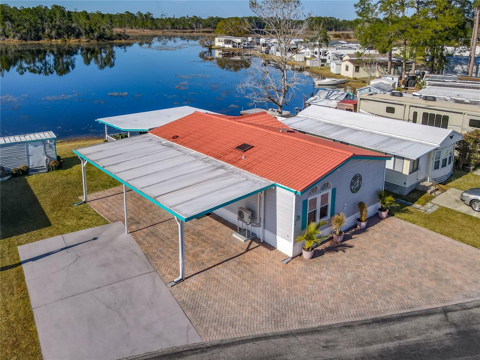 KOVE ESTATES - 55+ ACTIVE COMMUNITY - WATERFRONT & AFFORDABLE - DOUBLE WATERFRONT LOT- Perfect for the active retiree as a primary or second home. The gated community features a 9-hole golf course, two swimming pools, shuffleboard courts, pickleball courts, and two active clubhouses with regularly planned neighborhood events. Bring your RV & boat and park on your extra drive or in the special RV lot. The property is also conveniently located just one mile from the popular Rails-to-Trails bike path.Lovely inside and out there is a large paver drive with front paver patio/parking.

THE LAKE VIEWS FROM THIS HOME ARE A+.  YOU WILL CATCH FISH FROM YOUR OWN DECK! Inside, you will find an open floor plan with two spacious living areas and an abundance of windows that fill the home with natural light. The curved kitchen adds to the open flow and has a wood topped island with seating, as well as a separate dining area. The home has two bedrooms and two full bathrooms. The primary bedroom includes dual closets and a private en-suite bathroom with double vanity.
The high clerestory-style windows that bring in additional light while maintaining privacy. Updated flooring and decorative wainscoting along the walls adds charm and character throughout the main living areas. The living room windows overlook the lake and theback porch. THE 25 'COVERED BACK PORCH IS IDEAL FOR OUTDOOR LIVING & IS THE PERDFECT OUTDOORLIIVNG ROOM. THIS HOME TRULY CAPTURES THE ESSENCE OF FLORIDA LAKEFRONT.

Mint condition with 3 newer split AC systems which are very efficient and a metal roof. This is a rare opportunity to own an affordable lakefront home with resort-style amenities in a highly desirable community. Hoa includes all the amenities, water & sewer and trash pickup.