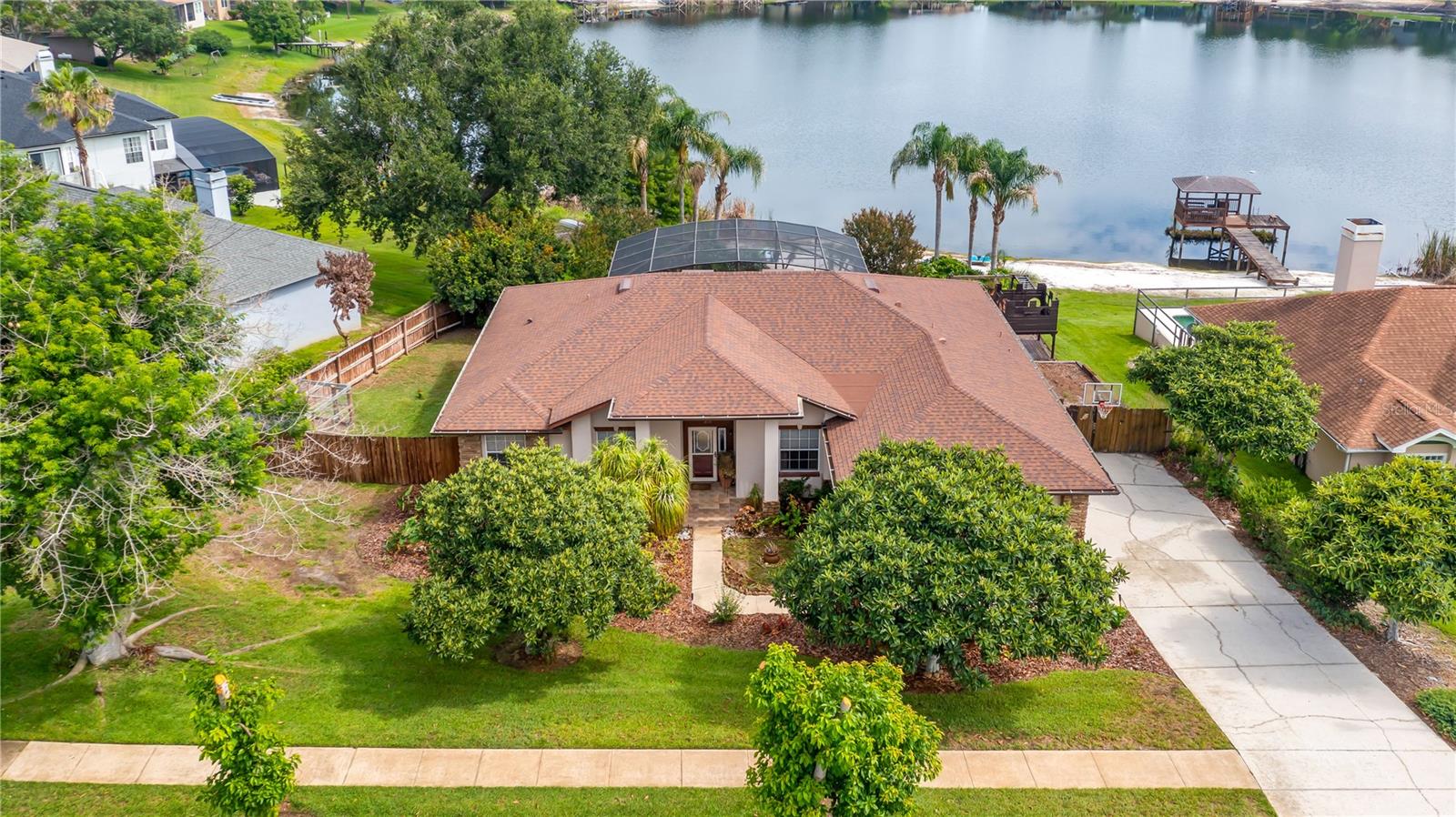 CLERMONT, FL LAKEFRONT living with private boat ramp access on the Clermont CHAIN OF LAKES!!  Don't just dream of paradise—live it. This exceptional 3-bedroom, 2-bath pool home with a bonus room is situated on an oversized ½-acre beachfront lot directly on Lake Katherine, a private spring-fed lake in the highly sought-after, established community of Lake Crescent Hills.

From the moment you step inside, you'll be captivated by the breathtaking views of the covered lanai, screened saltwater pool, white sandy beach, and sparkling lake beyond. Designed with both comfort and entertaining in mind, the open-concept great room, dining area, kitchen, and dinette create the perfect gathering space. Double doors open to a versatile office/flex room, while the impressive four-panel stacking sliding glass doors seamlessly blend indoor and outdoor living, expanding the space even further. The inviting entertainment wall provides the ideal setting to showcase your favorite décor, enjoy movie nights on a large TV, or cozy up by the fireplace. The kitchen features updated appliances, solid-surface countertops, and ample space for preparing meals and hosting guests.

The tastefully appointed primary suite offers a peaceful retreat with generous space, dual vanities, a soaking tub, a walk-in shower, and private access to the pool through elegant double glass doors. Bedroom two also enjoys direct pool access, while bedrooms two and three are thoughtfully separated by a guest bath featuring dual sinks and a tub/shower combination.

Outdoor living truly shines at this one-of-a-kind property. Enjoy both sunrises and sunsets over Lake Katherine from your own 90 feet of white sandy beach. Spend your days fishing, swimming, kayaking, paddle boarding, sunbathing, or quick rinse off at your outside shower deck and take a refreshing dip in the screened saltwater pool. The expansive side yards offer even more to love, including a chicken coop, playground, and dedicated boat parking with room for a 28'+ boat. Additional highlights include: NEW Roof (2020), NEW A/C (2024), NEW Pool Screen and Screen Doors 2025,Two mature avocado trees producing hundreds of avocados each year, Four producing loquat (Japanese plum) trees and a magnificent silk floss tree that bursts into stunning pink blooms seasonally.
Residents of Lake Crescent Hills also enjoy access to the community's private amenities, located just down the street, including a covered pavilion, playground, basketball hoop, private dock, and boat ramp on Lake Crescent, one of the most beloved lakes on the Clermont Chain of Lakes.
Conveniently located less than 5 miles from Historic Downtown Clermont and within approximately 40 miles of MCO International Airport, Walt Disney World® Resort and Central Florida's world-famous attractions, this property offers the perfect blend of peaceful lakefront living and everyday convenience.
Opportunities like this are rare. Schedule your private tour today and discover everything this extraordinary lakefront retreat has to offer.