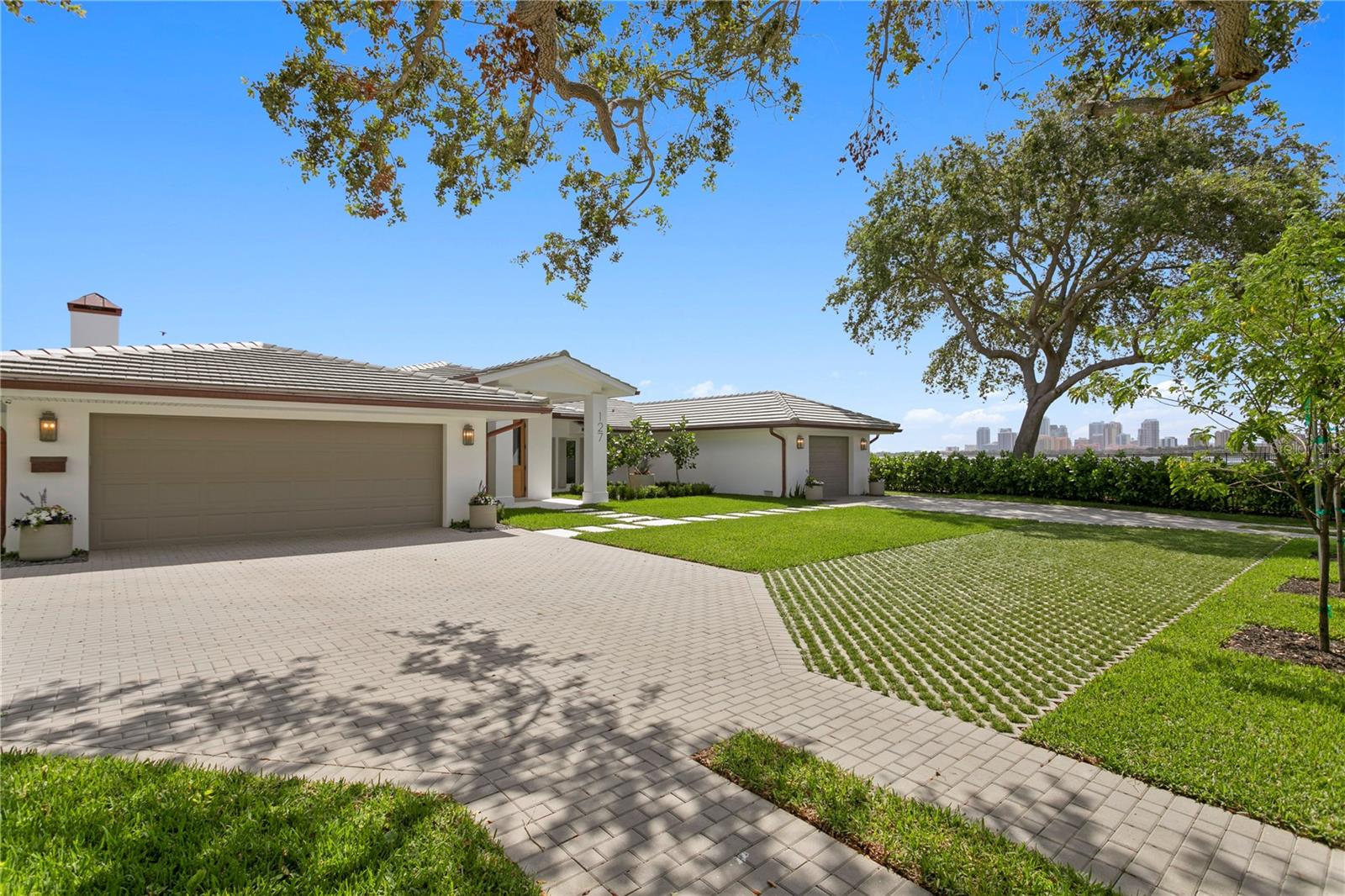 A  waterfront retreat on Snell Isle with one of the most mesmerizing views of the city.  Experience the impeccable craftsmanship and design of this  Resort Style,One Story Contemporary home with spectacular waterfront views of St Pete's downtown skyline. Elegance knows no bounds in this Palm Beach-inspired home that combines timeless contemporary materials with exceptional design. The saltwater heated  pool and the magnificent open water views of Tampa Bay create a picturesque backdrop, defining this home as an emblem of luxury living. Over 130 ft on the seawall, with new dock(2022) and 28000 lb lift, this 4 bedroom home with 3-car garage is great for entertaining both indoors and outdoors. The story of this home unfolds with a remodel that began as a vision, transforming the space from outdated finishes into an open, flowing, and versatile floor-plan. The result is a design that seamlessly showcases the stunning views and beauty of the waterfront and the  city's skyline.  A laid-back luxury lifestyle is the essence of this home. Step inside through the bespoke mahogany front door to reveal the structure's indoor-outdoor quality. Organic materials and finishes take center stage, with a focus on natural elements. Stone floors and subtle toned marbles grace every corner, harmonizing beautifully with the bleached walnut custom cabinetry, creating an atmosphere of tranquility. The list of impressive features continues with a new concrete tile roof, copper gutters, a marble paver patio, and pathways. Custom cabinetry is found throughout the home, enhancing both functionality and aesthetics. New hurricane windows and doors ensure security and comfort, while Miele appliances in the kitchen speak to the home's commitment to premium quality.
This property is lined with meticulously landscaped hedges, offering both privacy and natural beauty. The driveways and landscaping are works of art themselves, underscoring the attention to detail that defines this home. In addition to the waterfront  and views, the  location is prime- just minutes' drive  to downtown St Pete. Walk or bike to restaurants, events, galleries, coffee shops and all that St Pete has to offer.  Less than 30 minutes to the world renowned beaches and Tampa International airport.