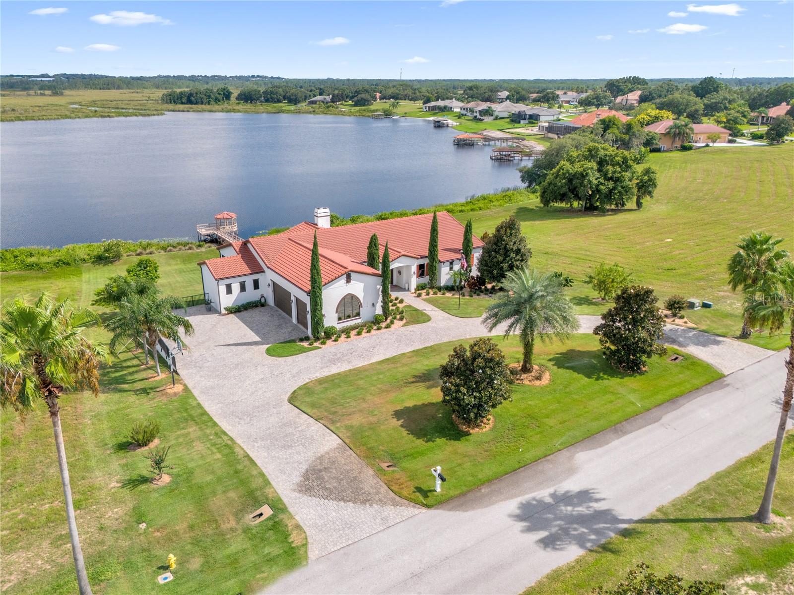 Instant Equity! Seller Says Sell! Explore the enchanting allure of this Florida paradise! Tucked away on nearly an acre of pristine land, this captivating family compound offers a luxurious retreat with breathtaking views of the upper Clermont Chain of Lakes. As you enter the property, you are greeted by a sense of tranquility and elegance, with an extensive half-moon Paver Driveway that easily accommodates 8+ vehicles. The property is meticulously designed with elegant Italian cypress and palm trees, as well as an array of mature fruit trees that add a touch of charm. Serene walkways and a delightful subdivision of trails enhance the inviting atmosphere, providing a perfect setting for leisurely strolls and various outdoor activities.

This expansive home spans nearly 4,200+/- square feet and is a true masterpiece of design and comfort. The property includes five spacious bedrooms, featuring two luxurious primary suites for ultimate comfort and privacy. There are also 4.5 elegantly designed bathrooms to cater to your needs. The home is equipped with three efficient A/C units to ensure a comfortable environment throughout. Additionally, you'll find two enclosed patios, providing serene outdoor spaces for relaxation and entertainment. The three-car garage offers ample space and convenience with a 9-foot door entry. An office room is also included, offering the flexibility to work from home in a comfortable setting. Lastly, an elevator is available for easy access to different levels of the house.

The focal point of the home is the expansive chef's kitchen and dining space, boasting a magnificent double island with stunning Quartz countertops. The kitchen is equipped with top-of-the-line appliances, including a built-in stove, a convenient microwave, and not one but two dishwashers, providing the perfect environment for both culinary masterpieces and sociable gatherings.

When you step outside, you'll be greeted by a spacious saltwater pool and a luxurious spa. Both are surrounded by enchanting lighting that creates an inviting ambiance for unforgettable outdoor gatherings and moments of pure relaxation. In addition, there's a screened-in lanai with a built-in half kitchen, featuring a sink, cooler, and a designated area for trash disposal right next to the pool.

In addition to its luxurious amenities, this residence ensures peace of mind and comfort with its two tankless water heaters and a fully automatic backup whole-house generator, guaranteeing readiness for any situation. This carefully designed and meticulously maintained property offers a truly exceptional living experience in the heart of Florida's natural beauty.