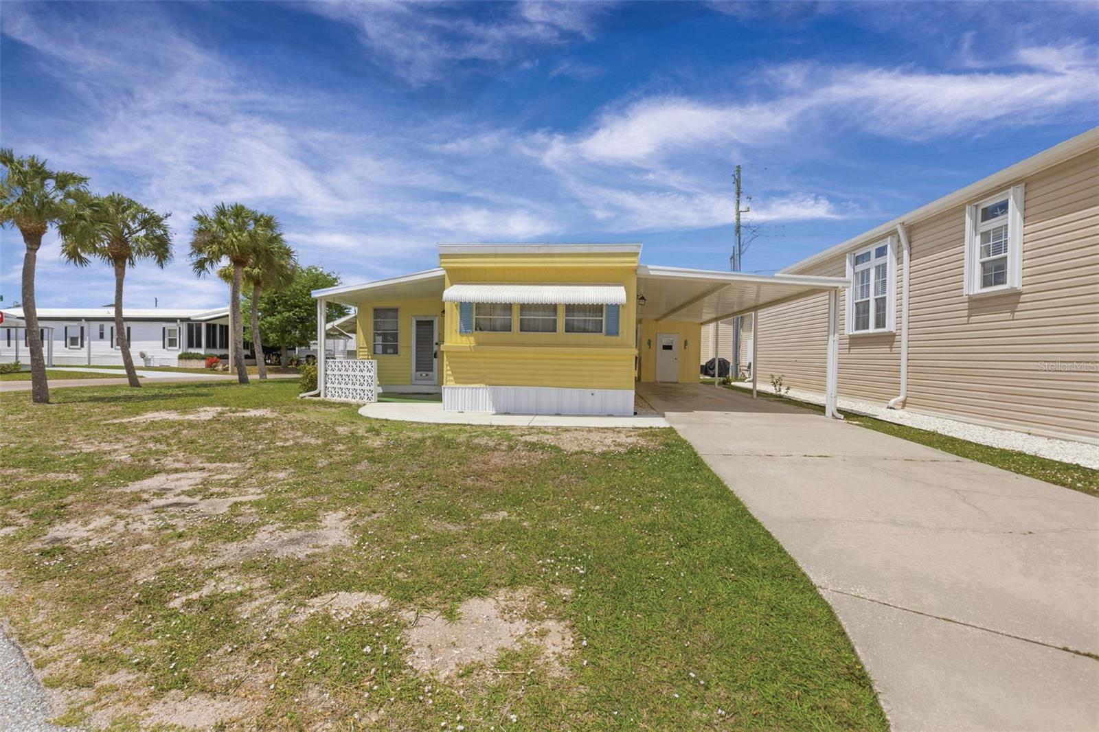 It's more than a home it's a lifestyle when you reside in the harbor front community of Country Club Estates in Venice.  This 2 bedroom, 1 bathroom retreat rests on a 4278SF corner-double lot and has a new roof (2024) and features a large bonus room with a new roof (2025) plus tile flooring, recessed lighting and a separate heating and cooling system.  Enjoy access to your rear lanai with a new aluminum roof (2024) or park your chair under the palm trees and catch some afternoon breezes in your private yard.  There's plenty of space for your vehicles in the extra long driveway with its' new aluminum carport (2024) which also houses an outside shed with your heat pump operated washer, dryer and hot water heater.  Money saving features already in place for you!  The kitchen has been outfitted with a new refrigerator and propane gas stove for your cooking pleasure while the dining room is tucked between the kitchen and the front facing living room.  A new concrete sidewalk greets you as you approach the front of the home and a cozy front porch with new aluminum roof (2024) allows for some breeze catching relaxation moments.  Country Club Estates is a 55+ community that offers a private harbor which connects to the intracoastal waterway offering access to the Gulf. Boat slips are available for rent. This amenity rich community offers a sparkling pool, pickleball, shuffleboard, corn hole, billiards, ping pong, fitness center, library, karaoke, holiday events, bands, community parades, social clubs and more!  Country Club Estates offers quick access to the Legacy Bike Trail, Venice beaches and the fabulous shops and restaurants on Venice Avenue.  Book your appointment to see this home today!